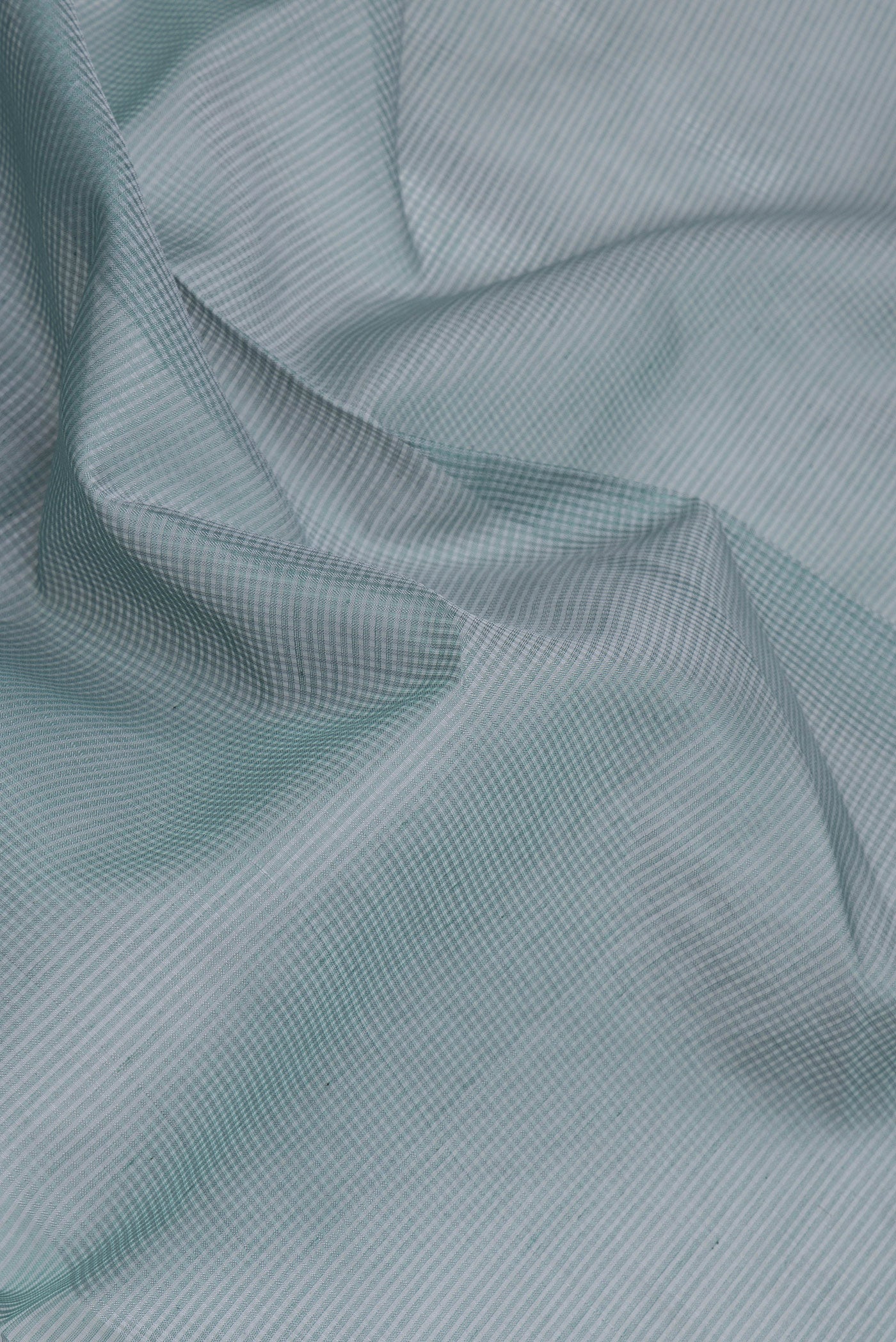 Close up of Sea Green Dual Tone Maheshwari Silk Saree with Stripes on the body and Zari Border.  displaying folds
