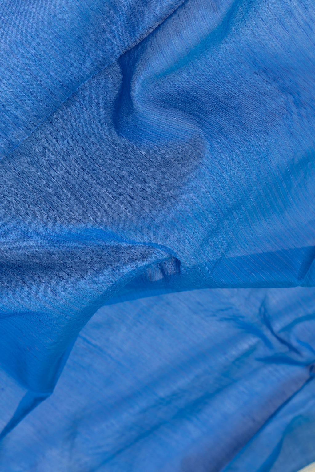 Close up of Royal Blue Dual Tone Maheshwari Silk Saree with Stripes on the body and Zari Border.  displaying folds