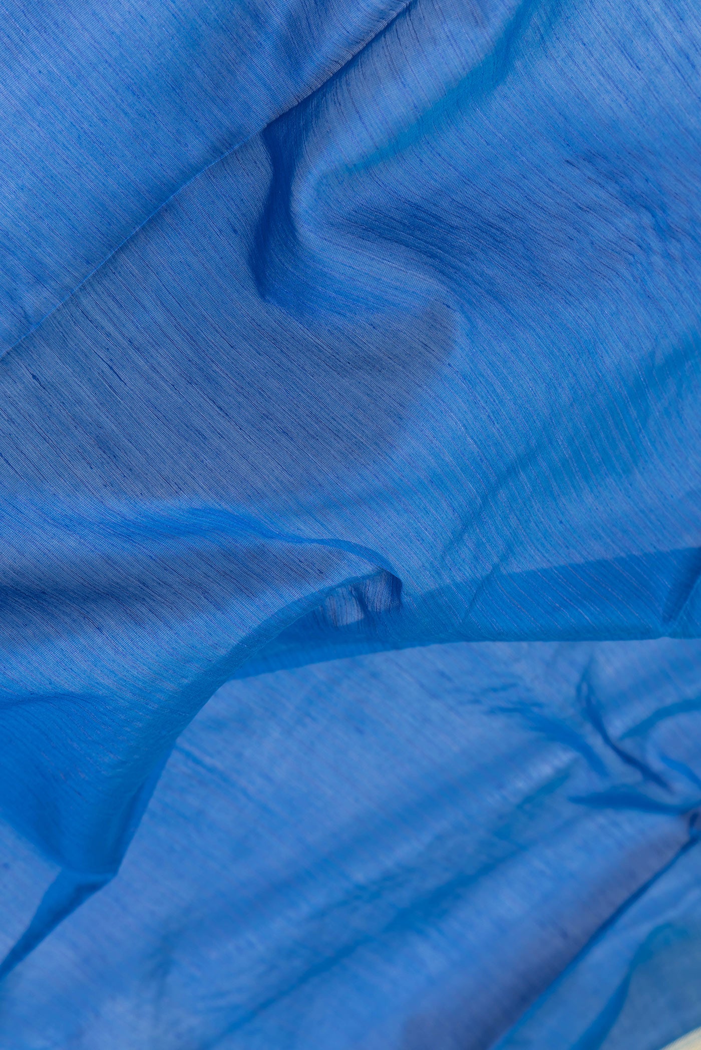 Close up of Royal Blue Dual Tone Maheshwari Silk Saree with Stripes on the body and Zari Border.  displaying folds