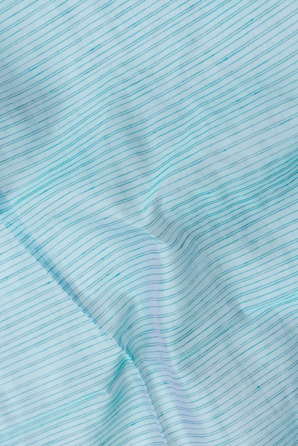 Close up of Sky Blue Dual Tone Maheshwari Silk Saree with Stripes on the body and Zari Border.  displaying folds