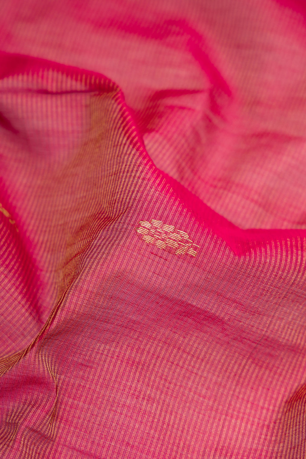 Close up of Rani Pink Dual Tone Maheshwari Silk Saree with Stripes on the body and Zari Border.  displaying folds