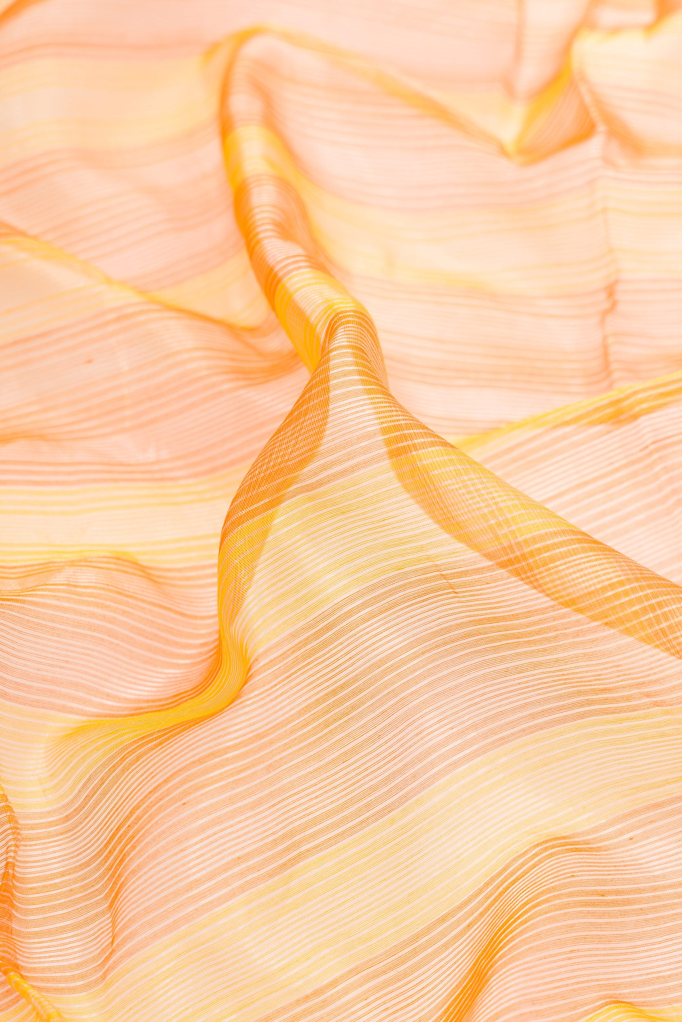 Close up of Orange and Yellow Color Maheshwari Silk Saree with Stripes on the body and Zari Border.  displaying folds
