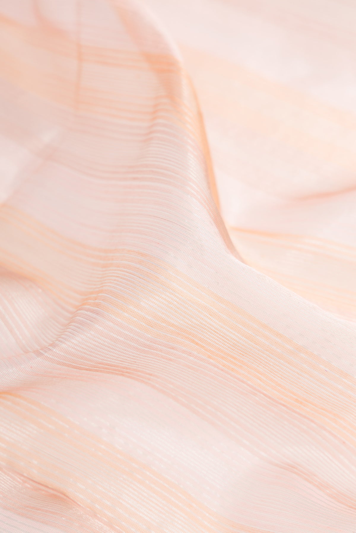 Close up of Rose Gold Maheshwari Silk Cotton Saree with Stripes on the body and Zari Border.  displaying folds