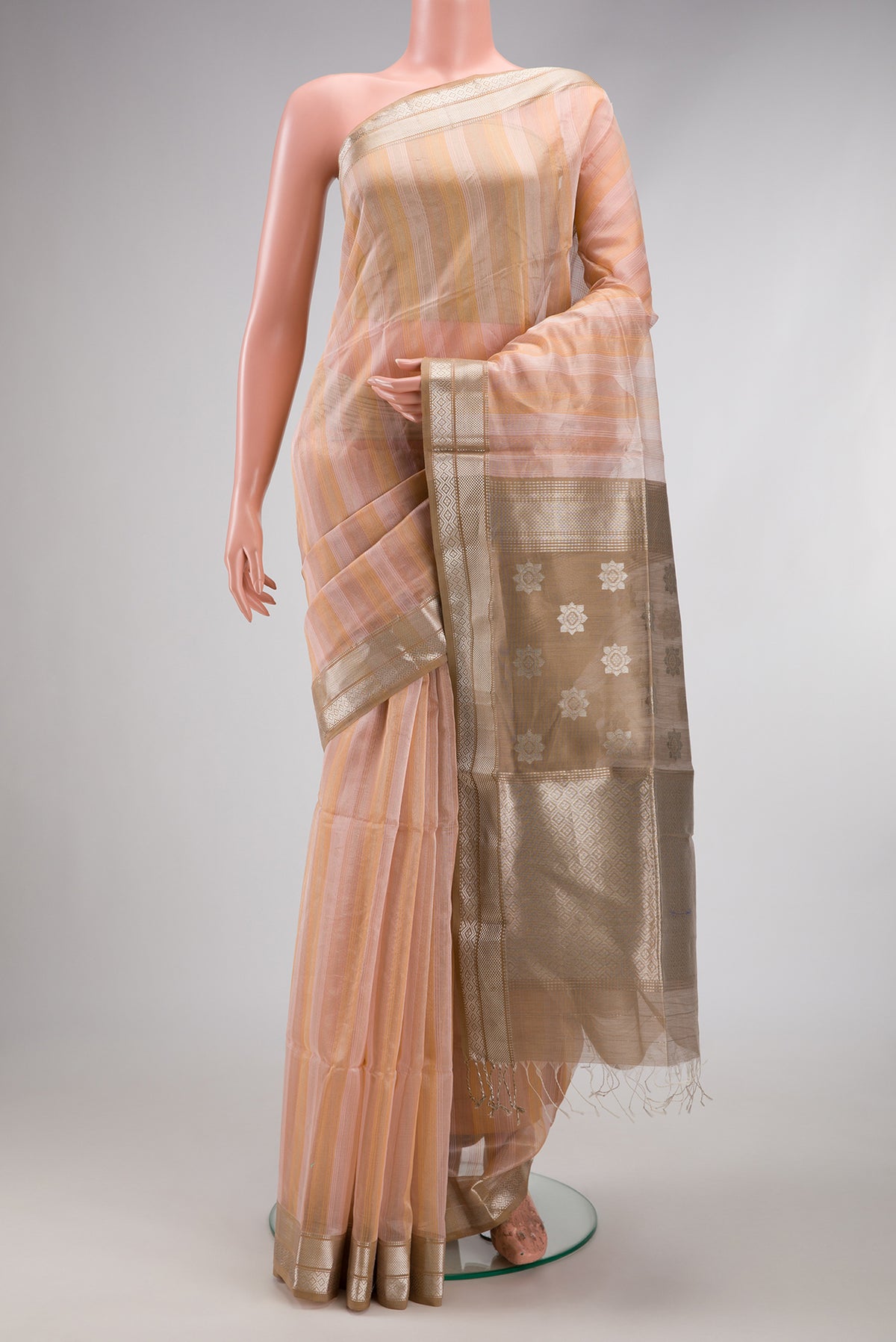 Rose Gold Maheshwari Silk Cotton Saree with Stripes on the body and Zari Border.  displayed on a mannequin