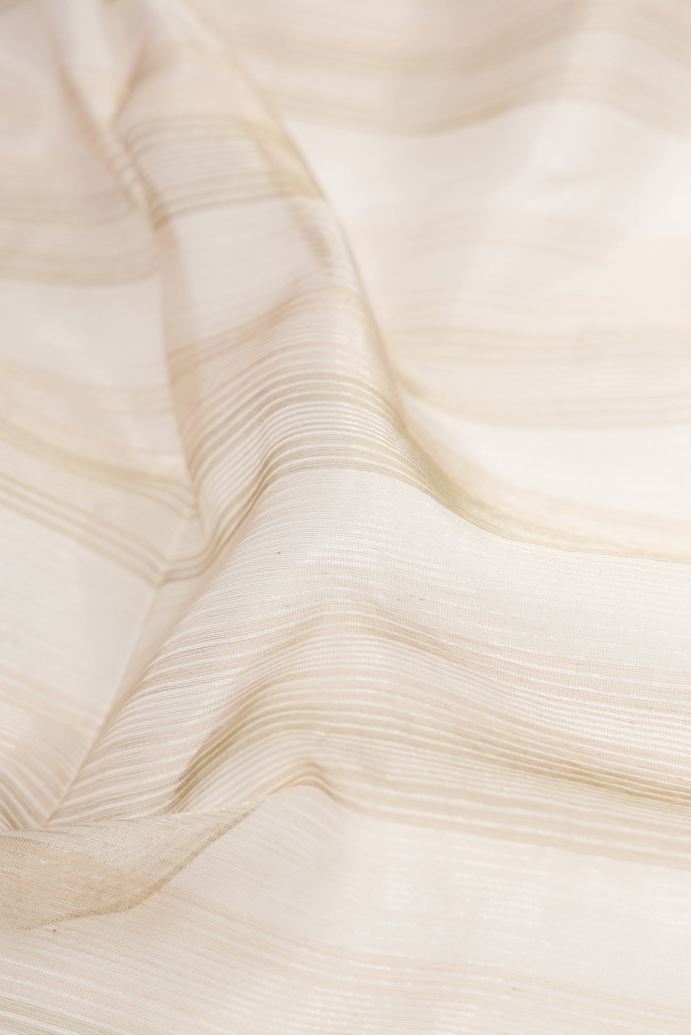 Close up of Dark Beige Dual Tone Maheshwari Silk Cotton Saree with Stripes on the body and Zari Border.  displaying folds