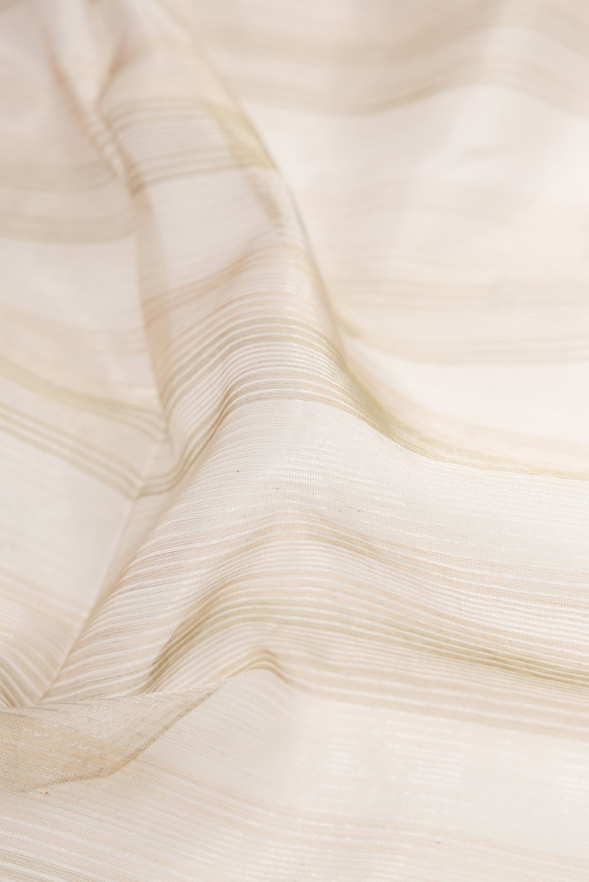 Close up of Dark Beige Dual Tone Maheshwari Silk Cotton Saree with Stripes on the body and Zari Border.  displaying folds