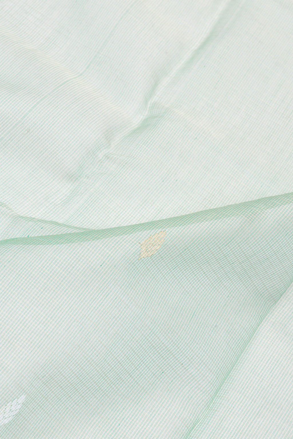 Close up of Pista Green Kota Silk Saree with Zari And Thread Butta on the body and Zari Border.  displaying folds