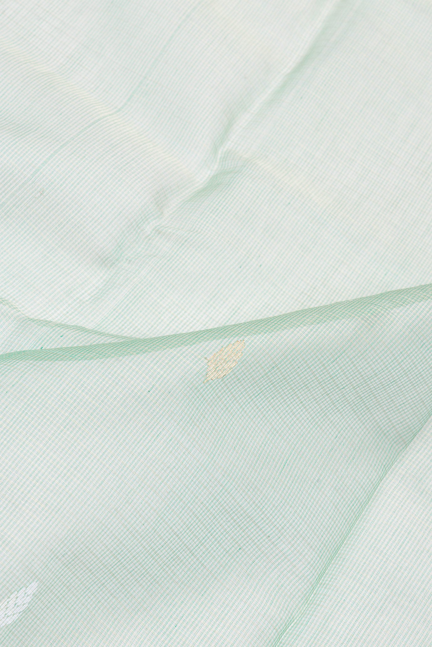 Close up of Pista Green Kota Silk Saree with Zari And Thread Butta on the body and Zari Border.  displaying folds