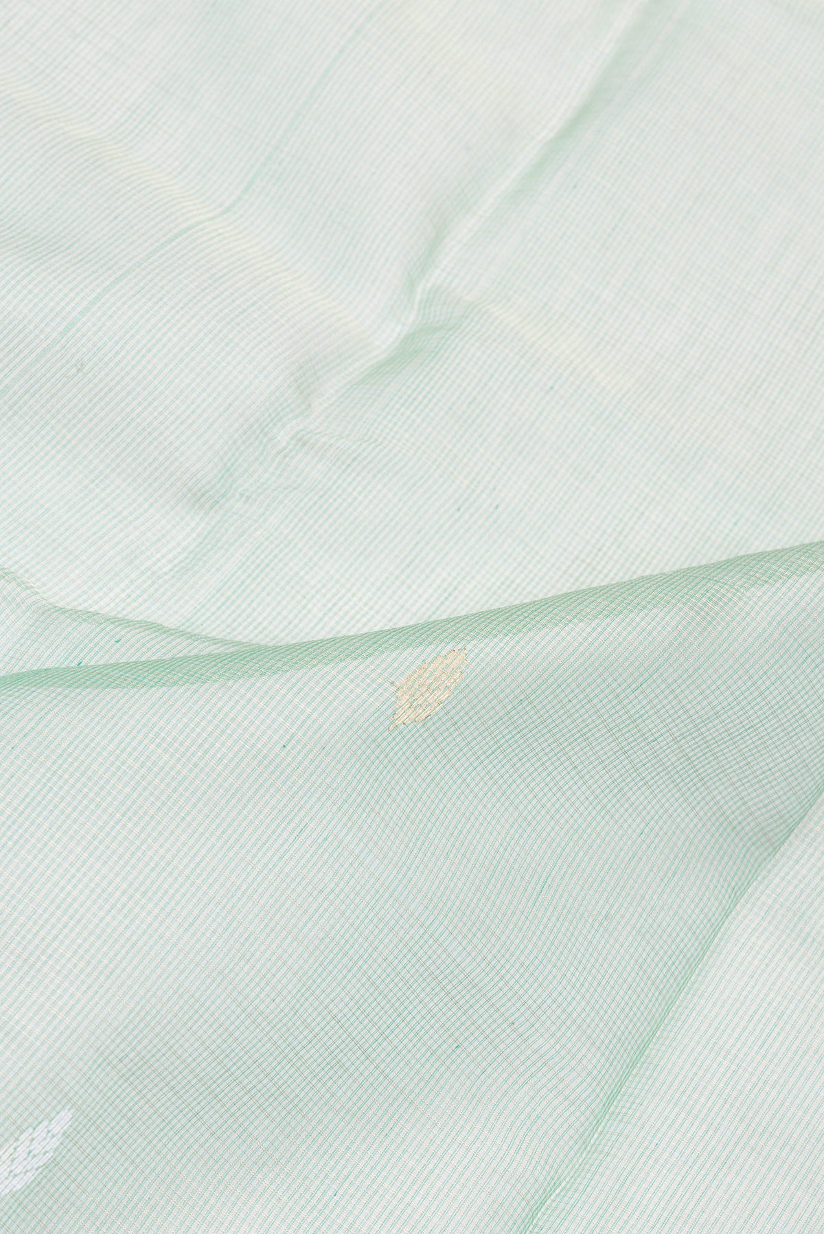 Close up of Pista Green Kota Silk Saree with Zari And Thread Butta on the body and Zari Border.  displaying folds