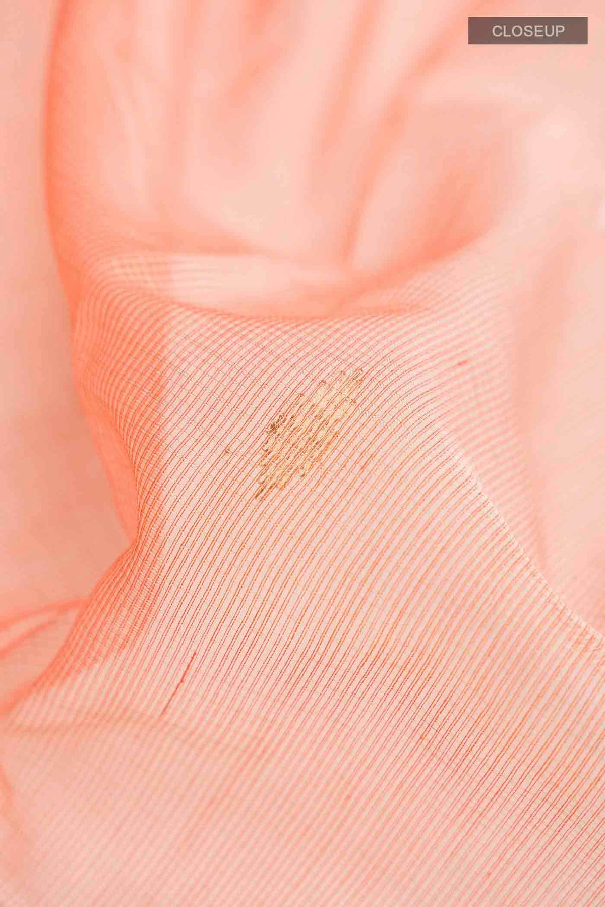 Close up of Orange Maheshwari Silk Cotton Saree with Zari Butta on the body and Zari Border displaying folds