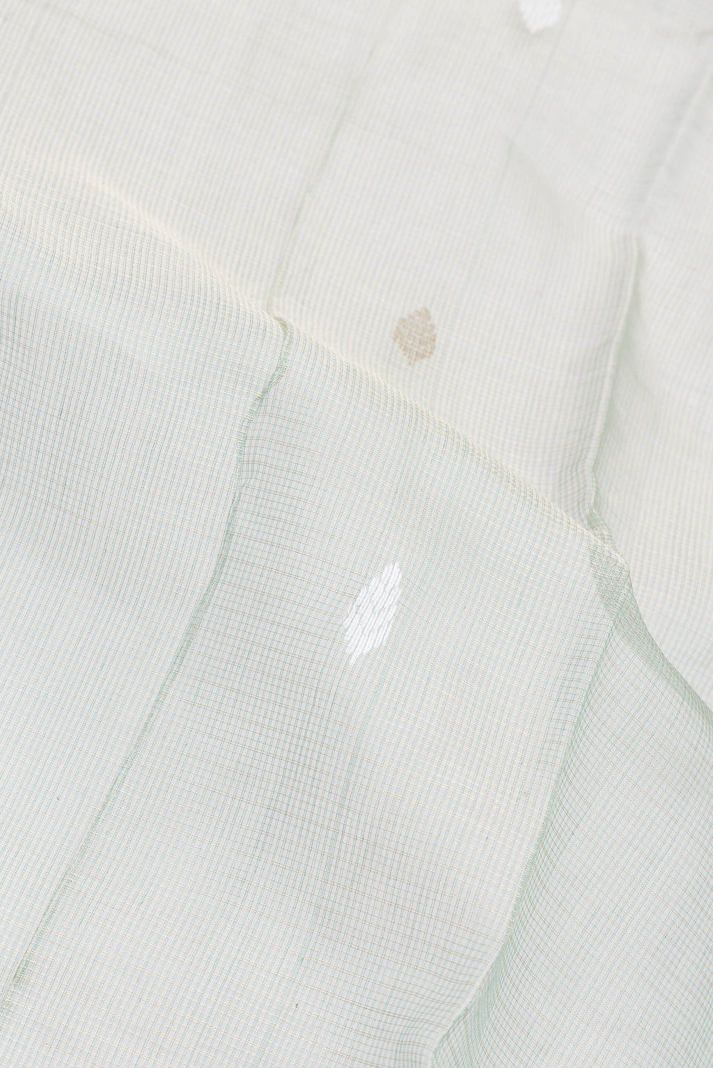 Close up of Sage Green Kota Silk Saree with Checked design on the body and Zari Border.  displaying folds