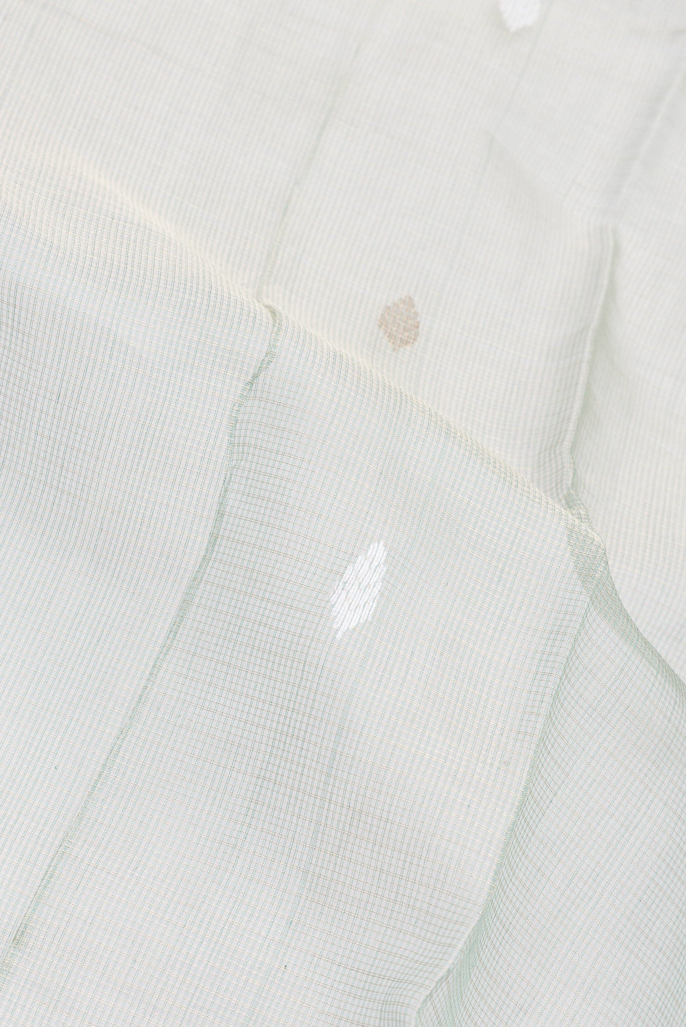 Close up of Sage Green Kota Silk Saree with Checked design on the body and Zari Border.  displaying folds