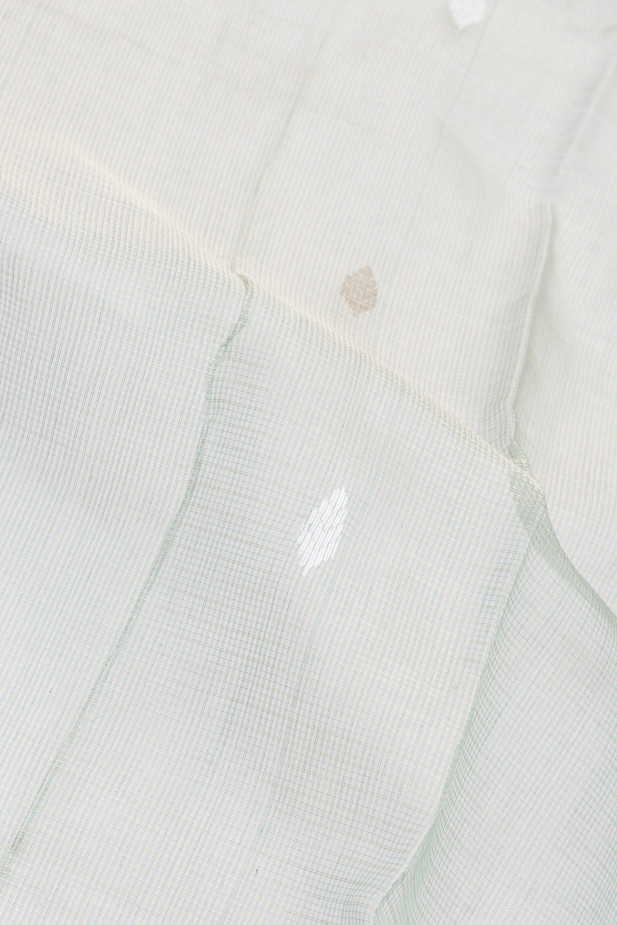 Close up of Sage Green Kota Silk Saree with Checked design on the body and Zari Border.  displaying folds