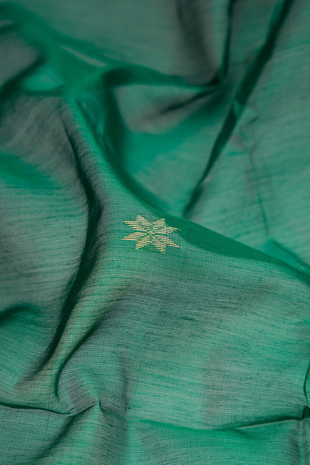 Close up of Green Dual Tone Maheshwari Silk Cotton Saree with Zari Butta on the body and Zari Border.  displaying folds