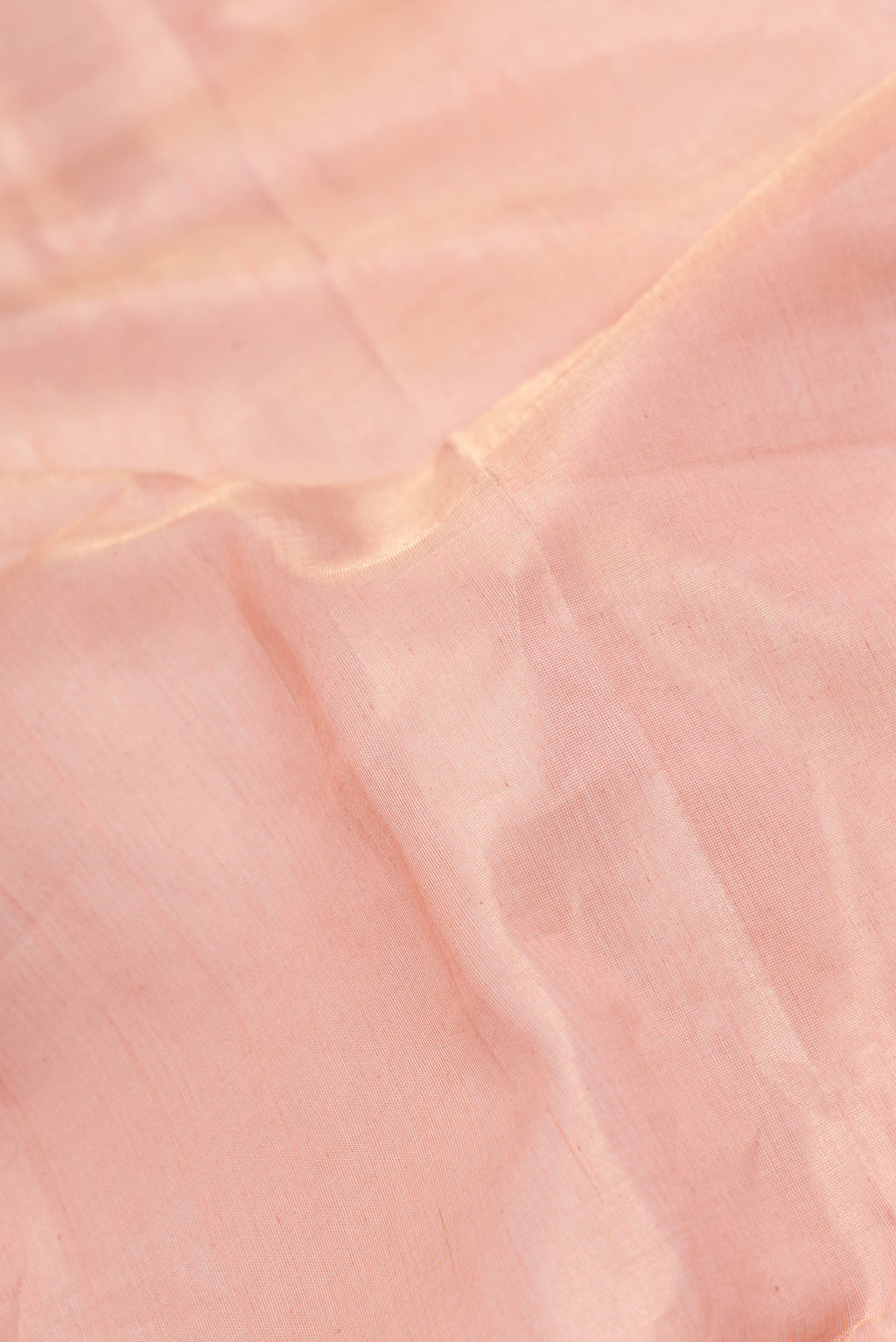 Close up of Rose Gold Dual Tone Maheshwari Silk Saree with Plain Body and Zari Border.  displaying folds