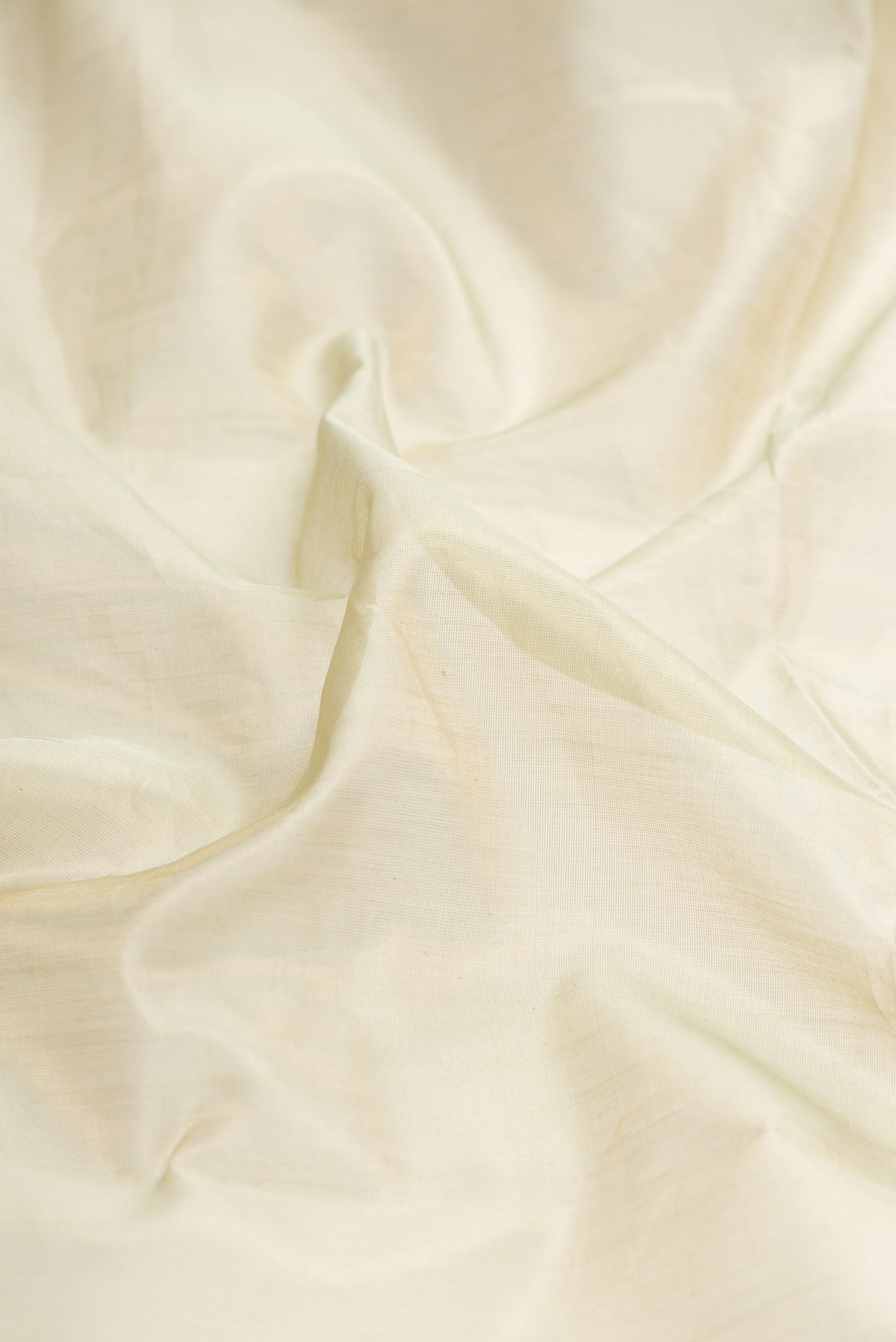 Close up of Pista Green Dual Tone Maheshwari Tissue Silk Saree with Plain Body and Zari Border.  displaying folds