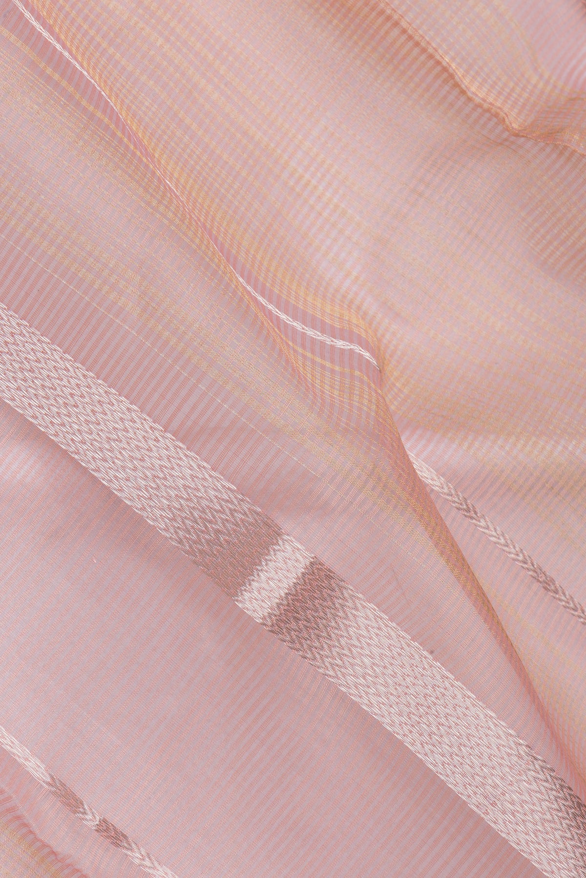 Close up of Golden Peach Maheshwari Silk Saree with Checked design on the body and Zari Border.  displaying folds