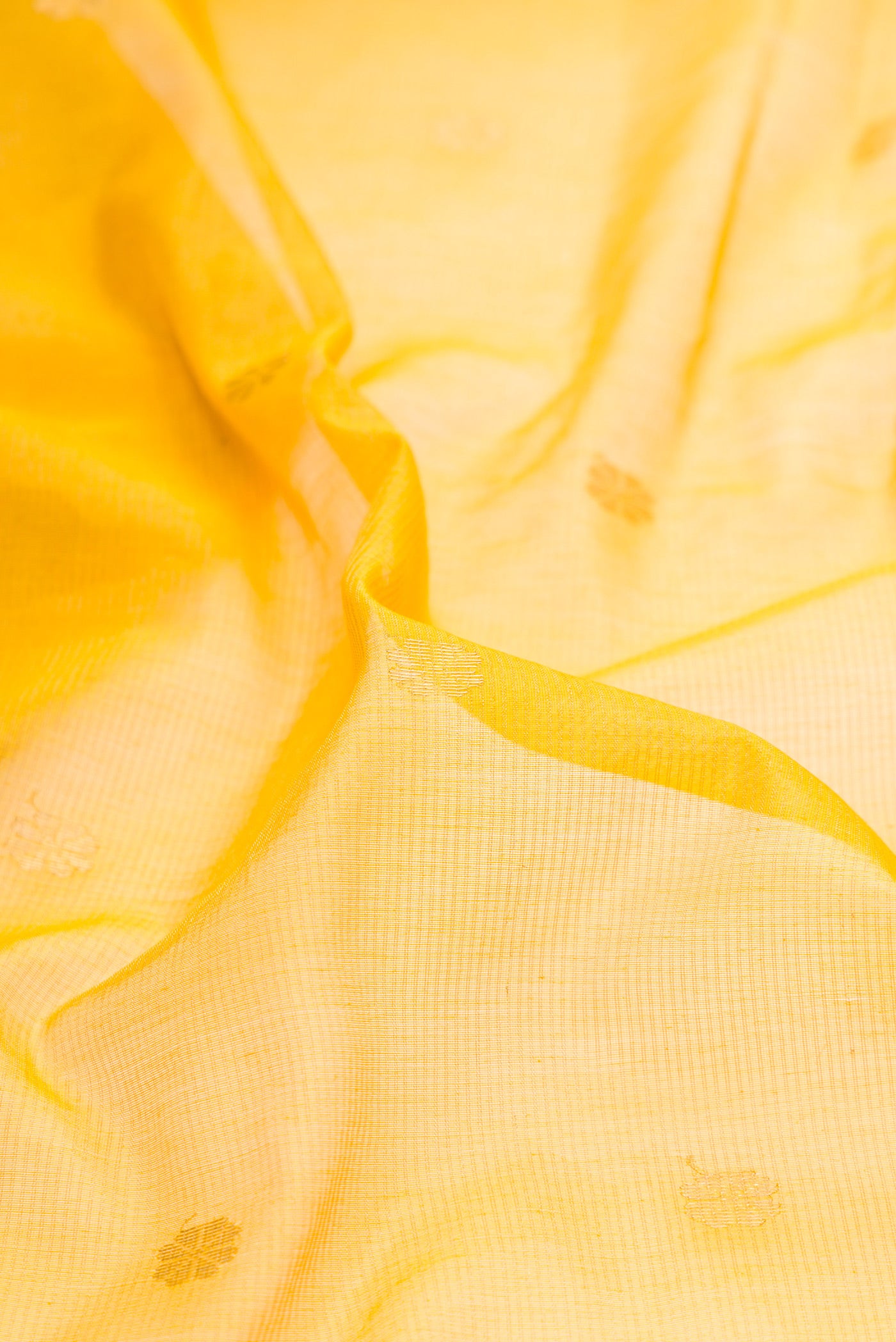 Close up of Yellow Dual Tone Maheshwari Tissue Silk Saree with Zari Butta on the body and Zari Border.  displaying folds
