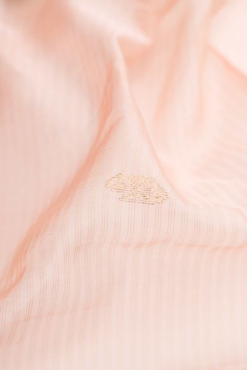 Close up of Rose Gold Dual Tone Maheshwari Silk Cotton Saree with Stripes on the body and Zari Border.  displaying folds