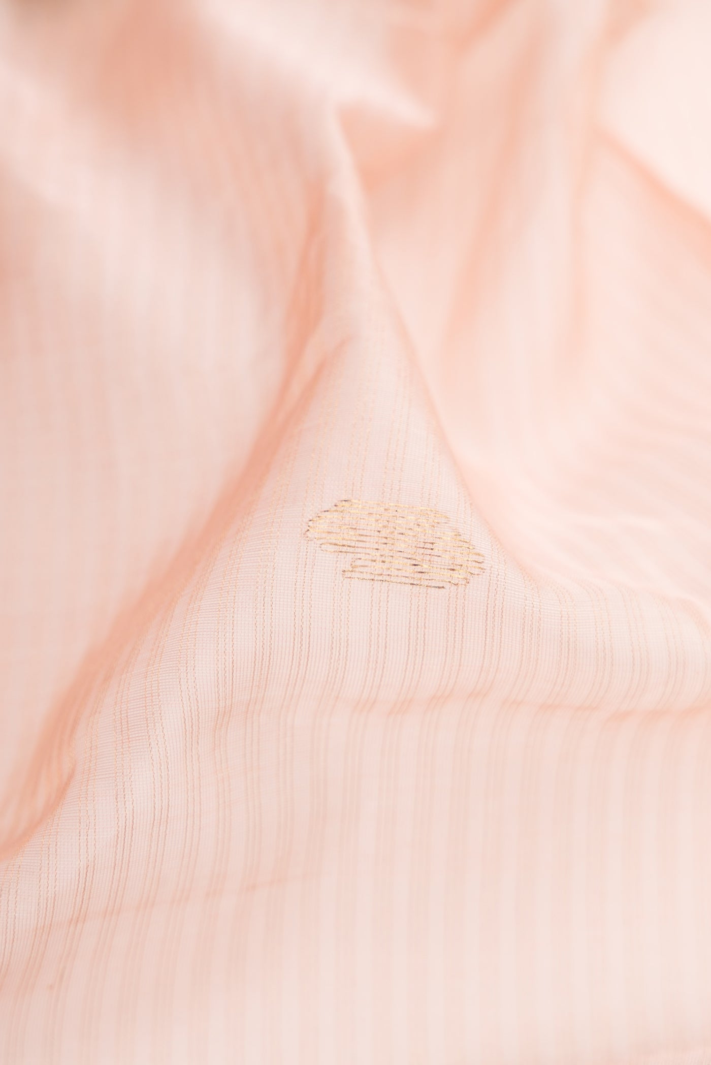 Close up of Rose Gold Dual Tone Maheshwari Silk Cotton Saree with Stripes on the body and Zari Border.  displaying folds
