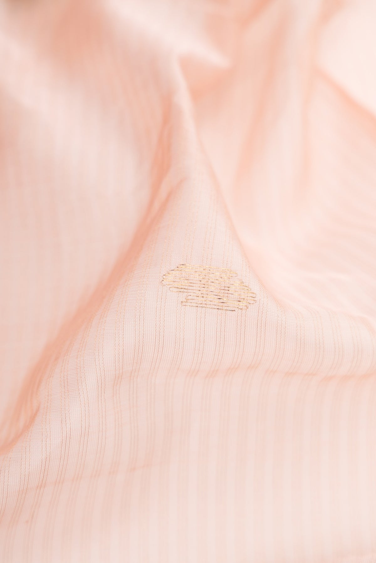 Close up of Rose Gold Dual Tone Maheshwari Silk Cotton Saree with Stripes on the body and Zari Border.  displaying folds