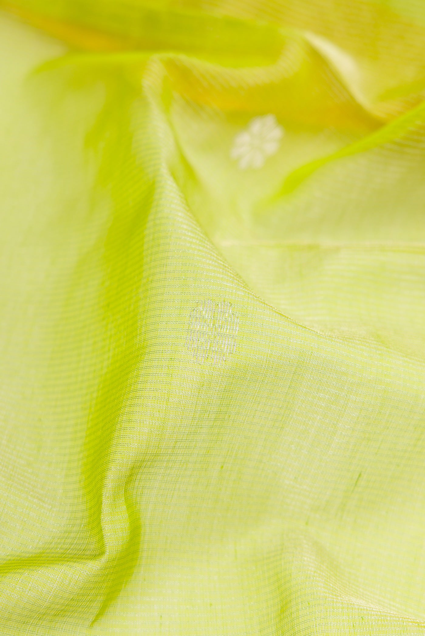 Close up of Parrot Green Dual Tone Maheshwari Silk Cotton Saree with Zari Butta on the body and Zari Border.  displaying folds