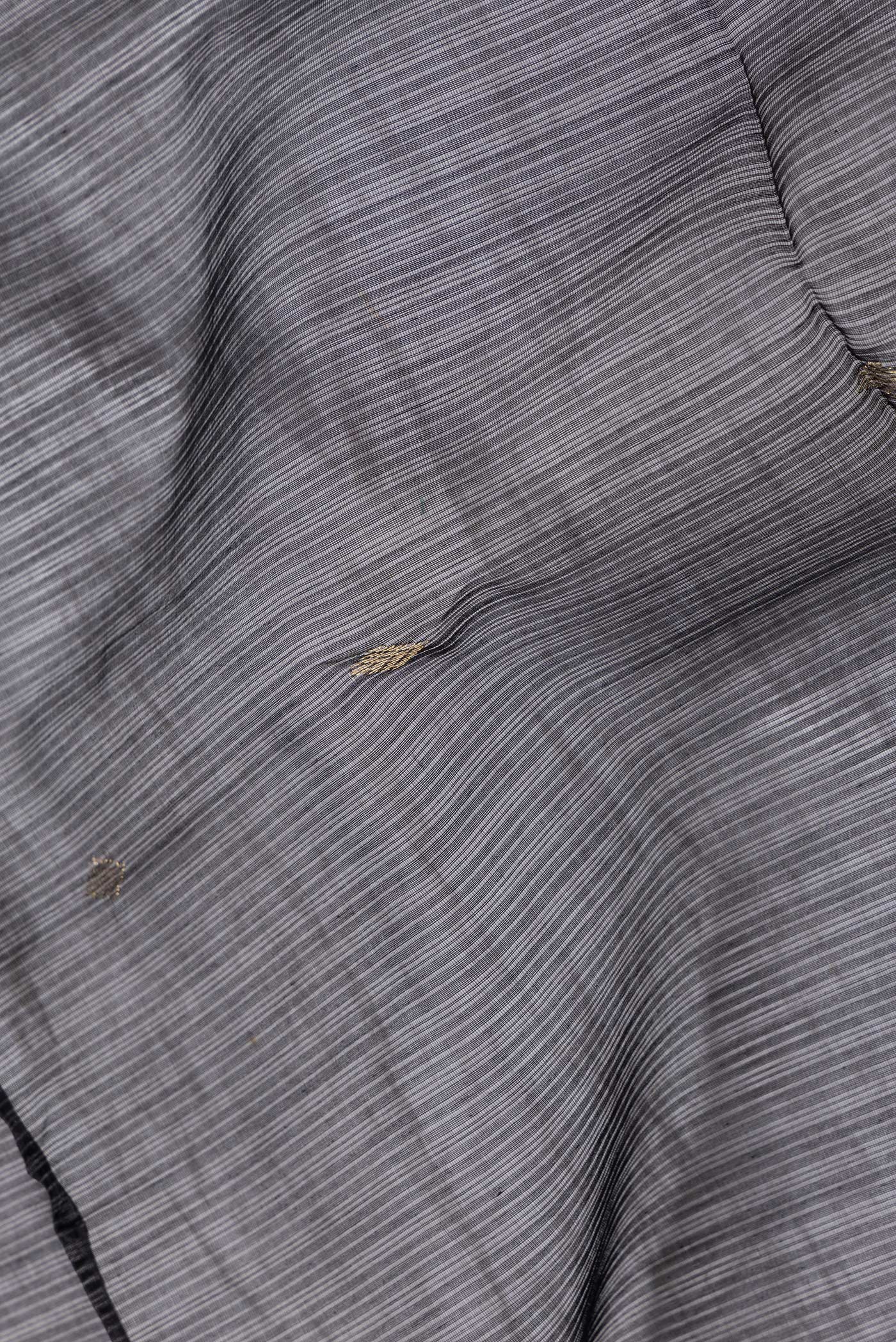 Close up of Black Dual Tone Maheshwari Silk Saree with Zari Butta on the body and Zari Border.  displaying folds