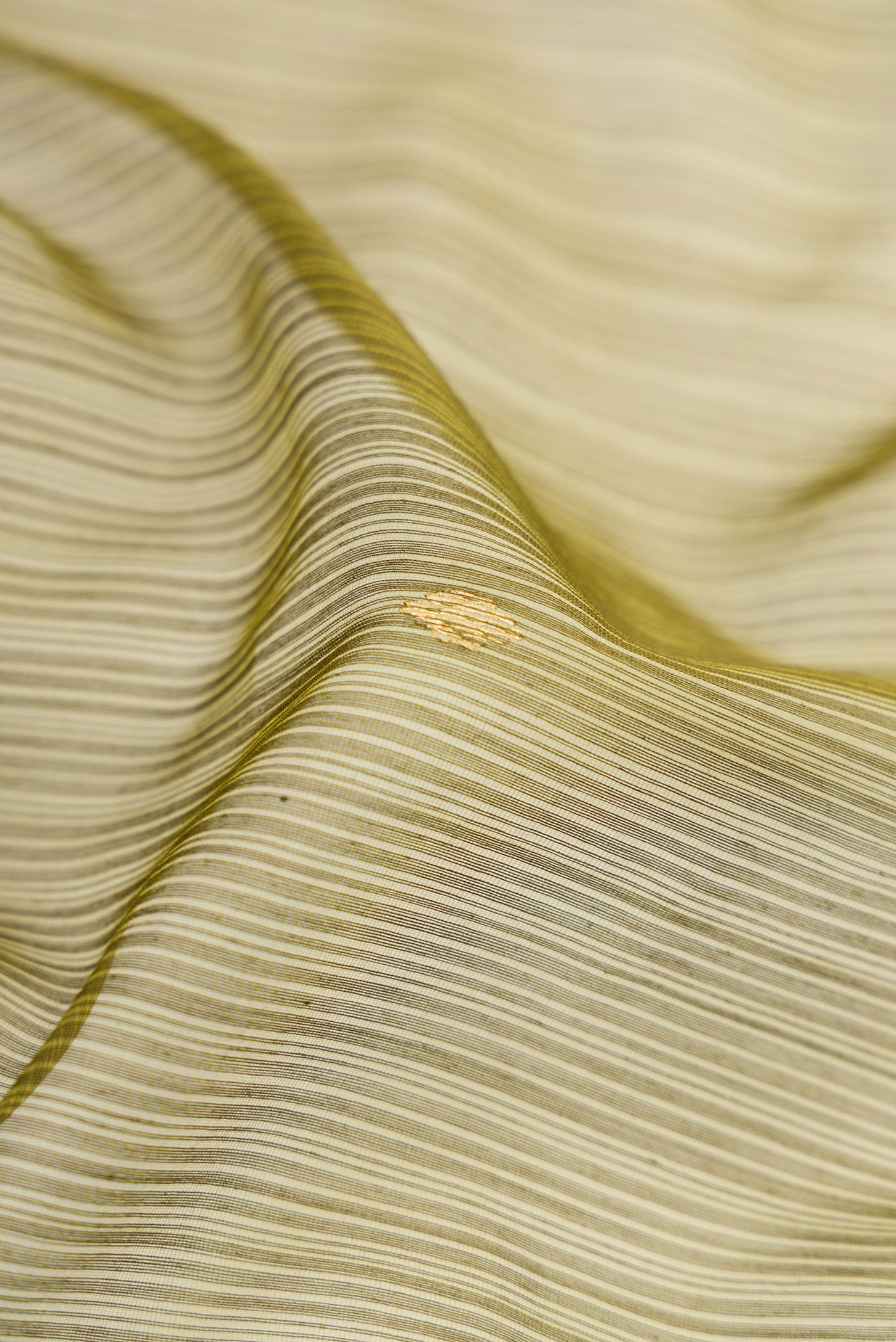 Close up of Green Dual Tone Maheshwari Silk Cotton Saree with Zari Butta on the body and Zari Border.  displaying folds