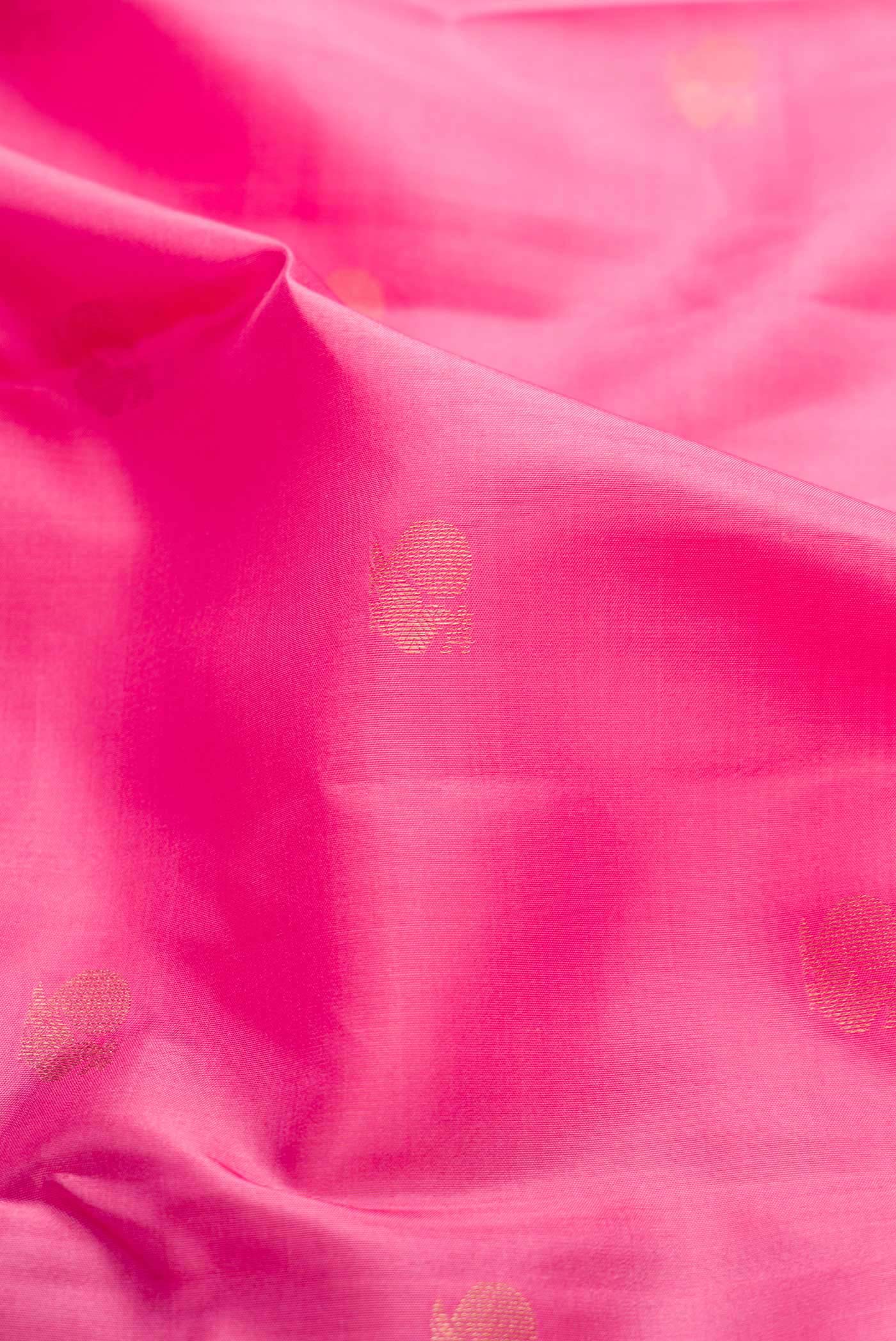 Close up of Pink Dual Tone Kanchipuram Silk Saree with Zari Butta on the body and Zari Border displaying folds