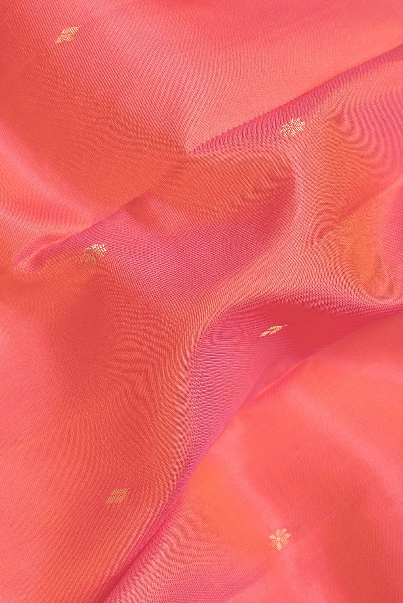 Close up of Peach Dual Tone Kanjivaram Silk Saree with Zari Butta on the body and Zari Border.  displaying folds