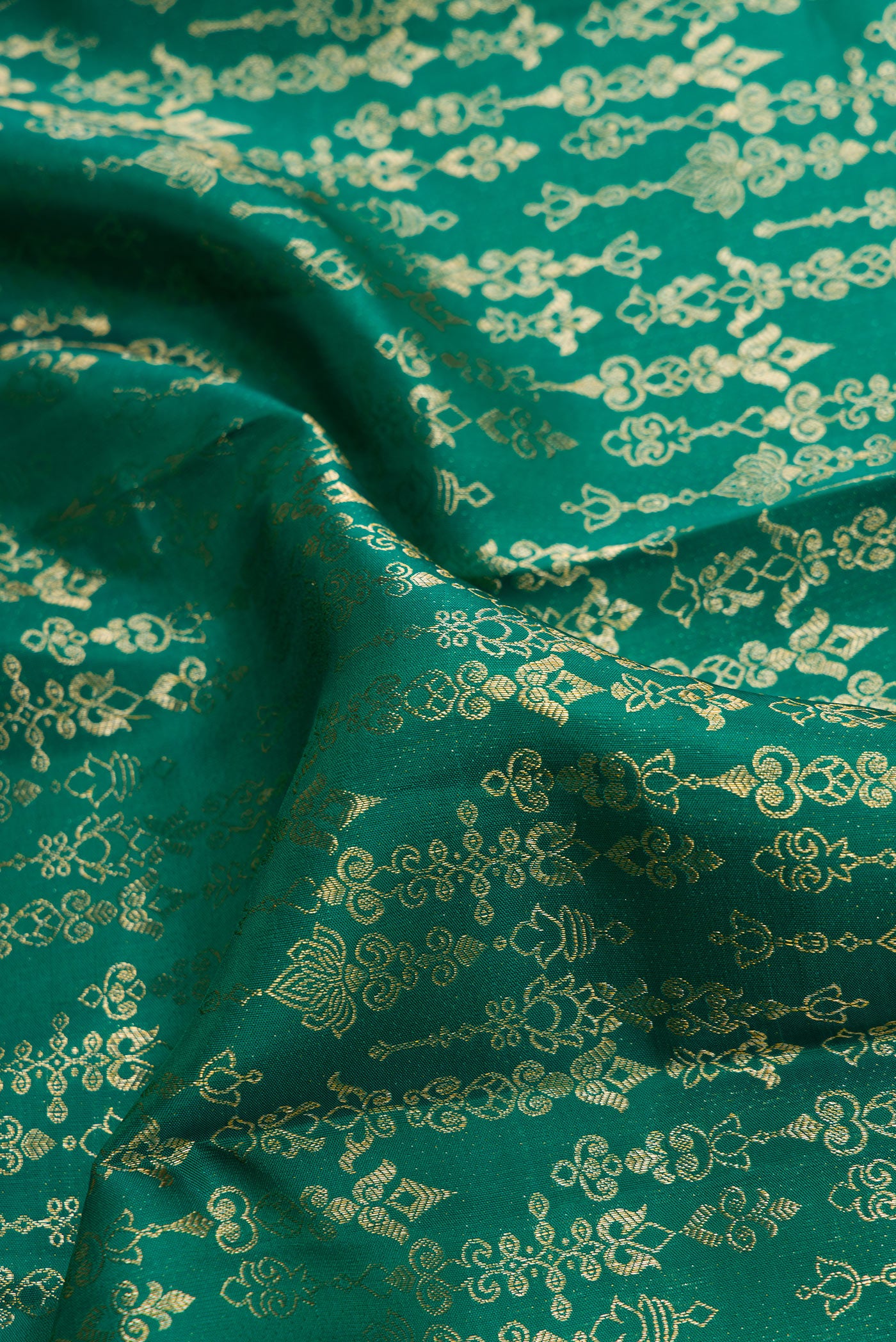 Close up of Green Dual Tone Kanchipuram Silk Saree with Zari Butta on the body and Zari Border.  displaying folds