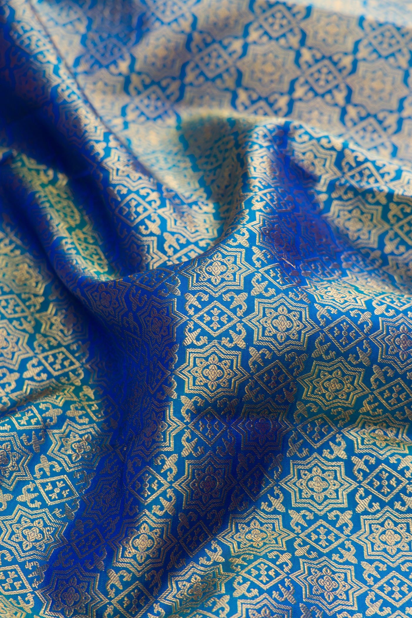 Close up of Peacock Blue Dual Tone Kanchipuram Silk Saree with Zari Brocade on the body and Zari Border.  displaying folds