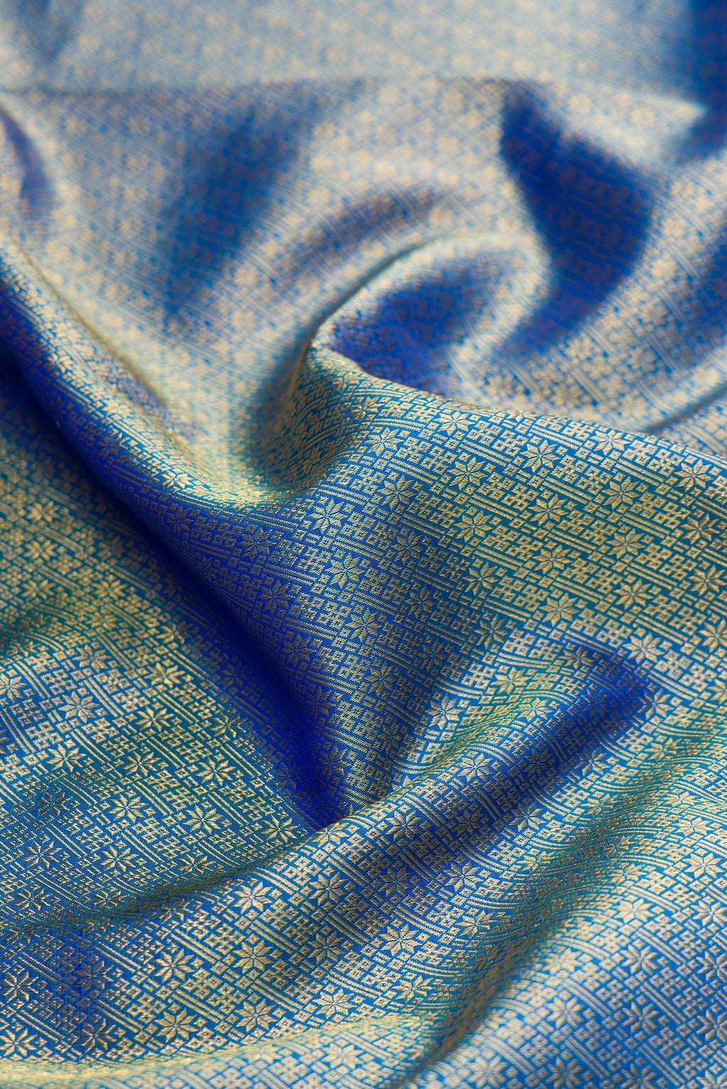 Close up of Peacock Blue Dual Tone Kanchipuram Silk Saree with Zari Brocade on the body and Zari Border.  displaying folds