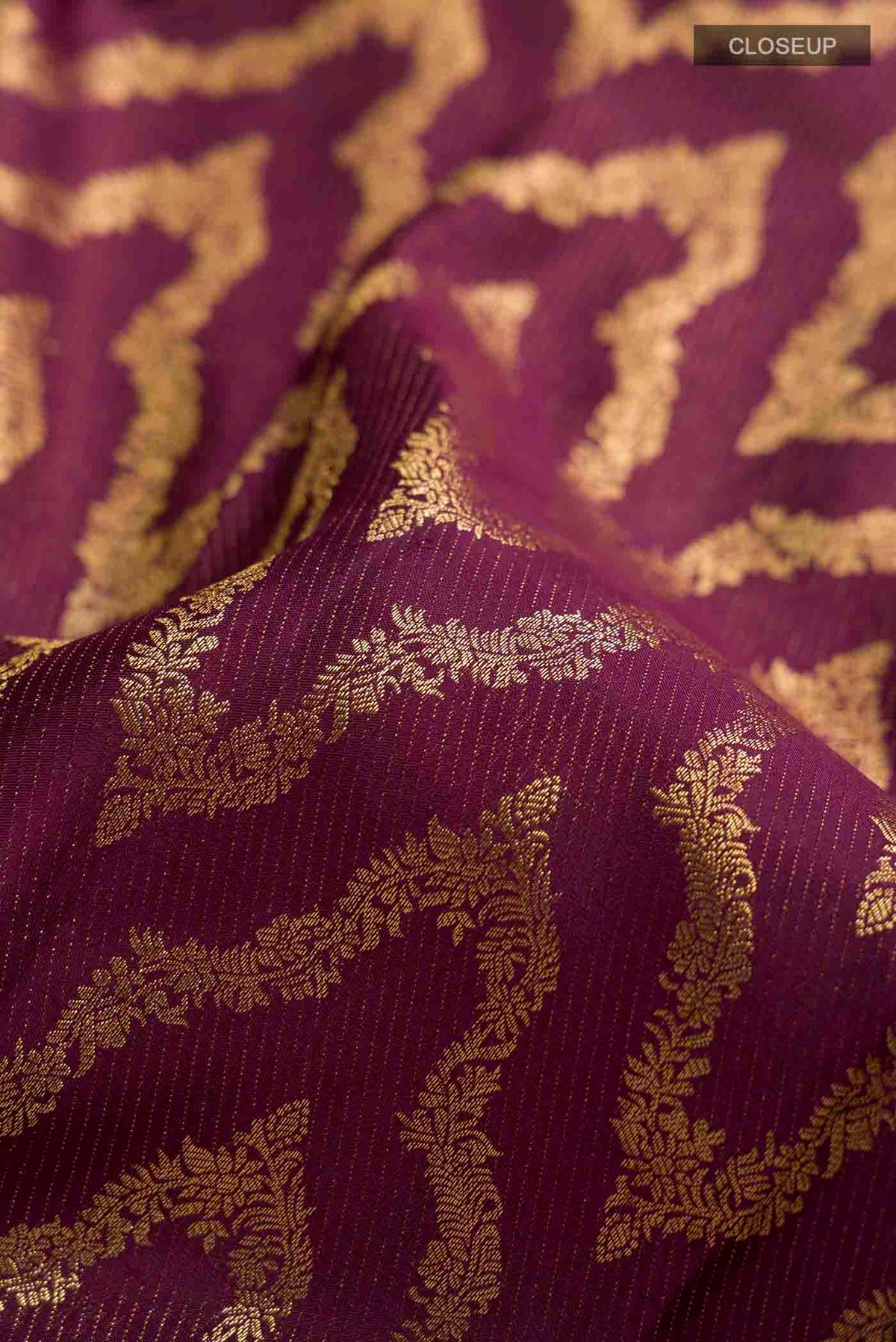 Close up of Burgundy Kanchipuram Silk Saree with Zari Brocade on the body and Zari Border displaying folds
