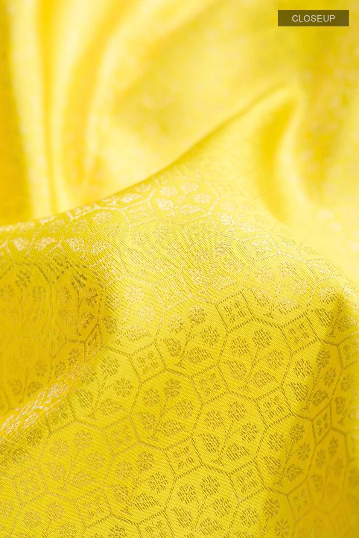 Close up of Yellow Kanchipuram Silk Saree with Zari Brocade on the body and Zari Border displaying folds