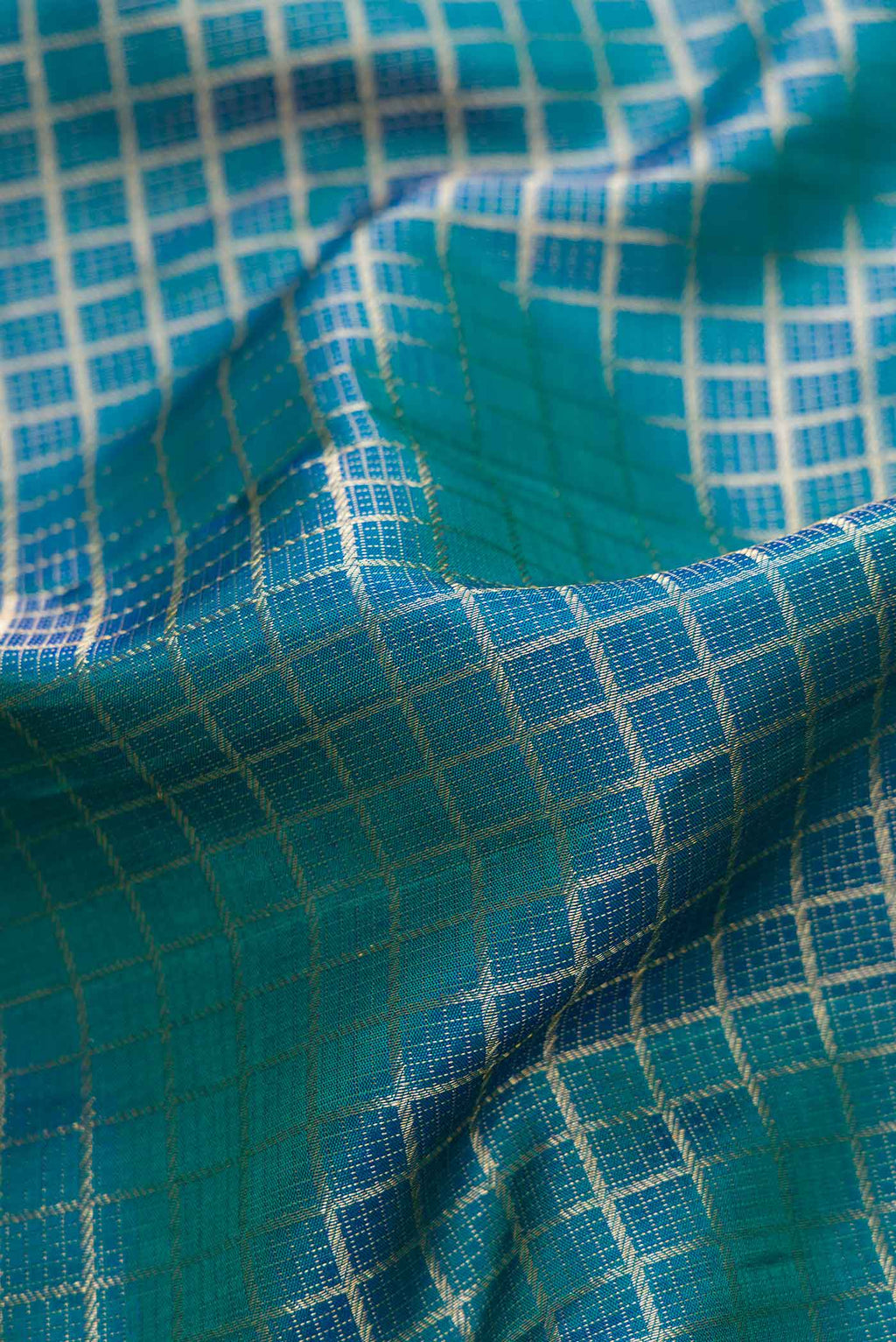 Close up of Peacock Blue Dual Tone Kanchipuram Silk Saree with Zari Brocade on the body and Zari Border.  displaying folds