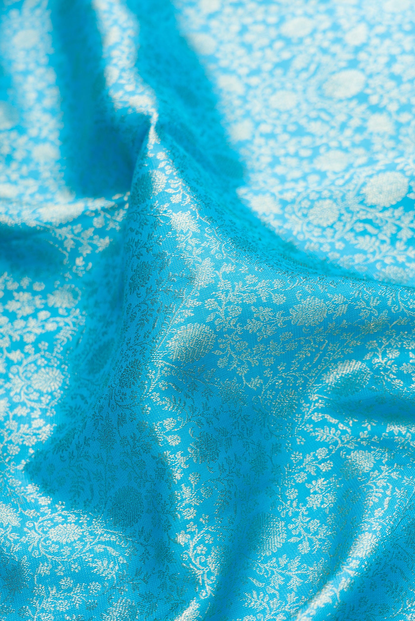 Close up of Sky Blue Dual Tone Kanchipuram Silk Saree with Zari Brocade on the body and Fancy Border.  displaying folds