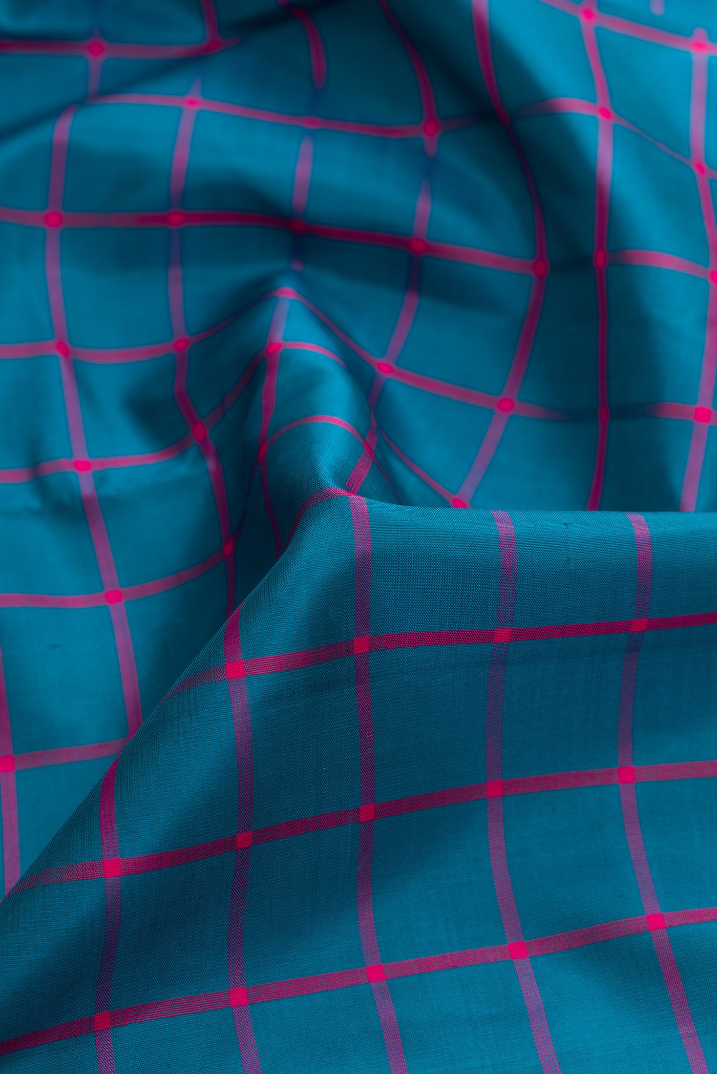 Close up of Peacock Blue Dual Tone Kanjivaram Silk Saree with Checked design on the body and Zari Border.  displaying folds