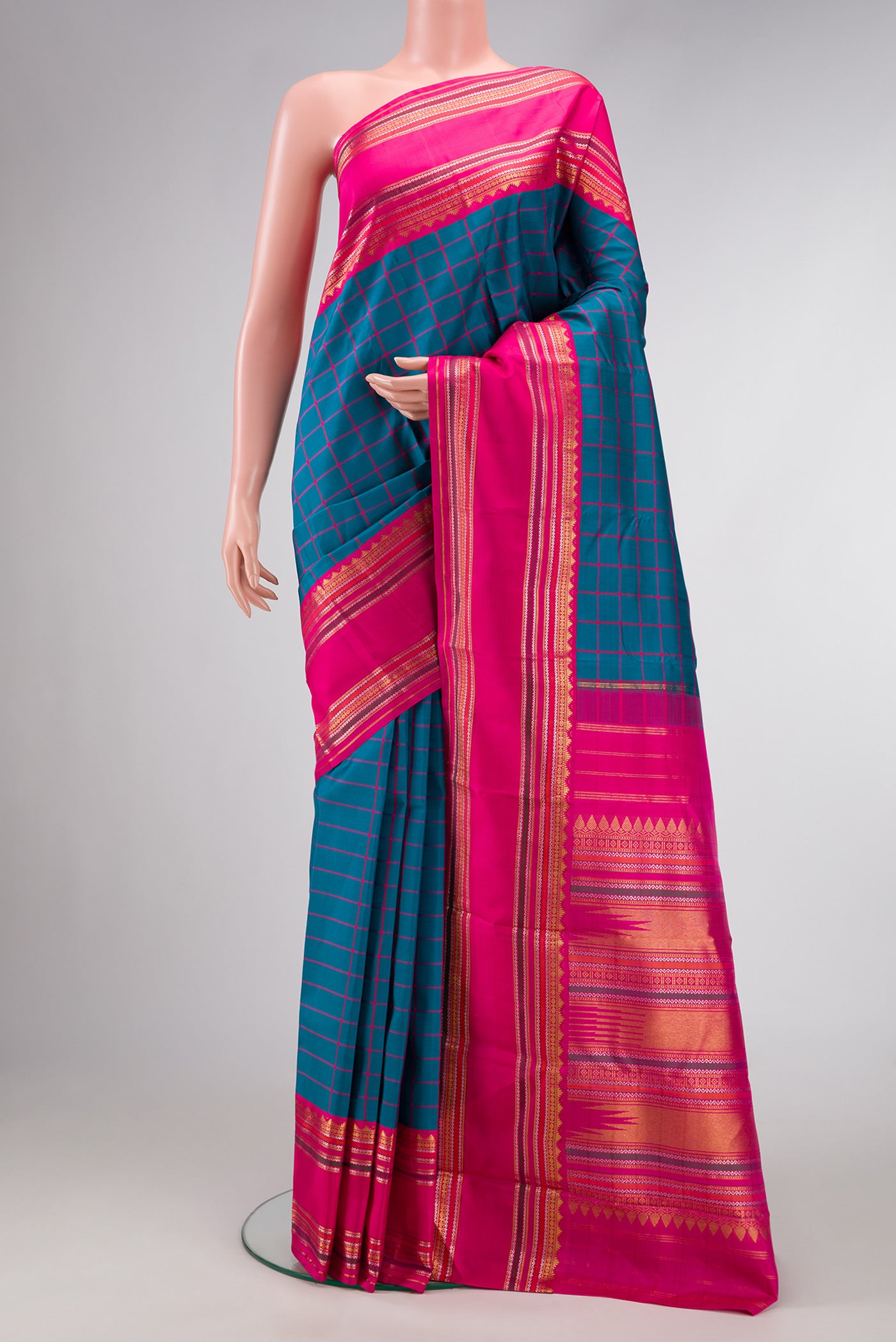 Peacock Blue Dual Tone Kanjivaram Silk Saree with Checked design on the body and Zari Border.  displayed on a mannequin