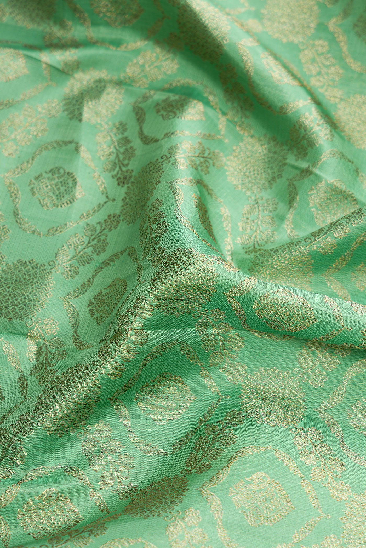 Close up of Green Dual Tone Kanchipuram Silk Saree with Zari Brocade on the body and Zari Border.  displaying folds