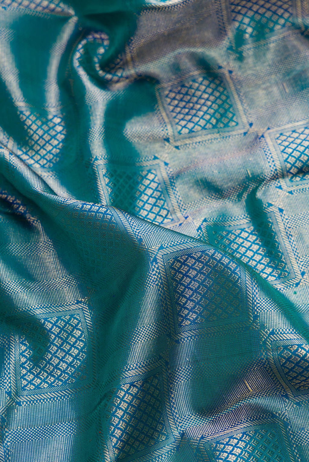 Close up of Peacock Blue Dual Tone Kanchipuram Silk Saree with Zari Brocade on the body and Zari Border.  displaying folds
