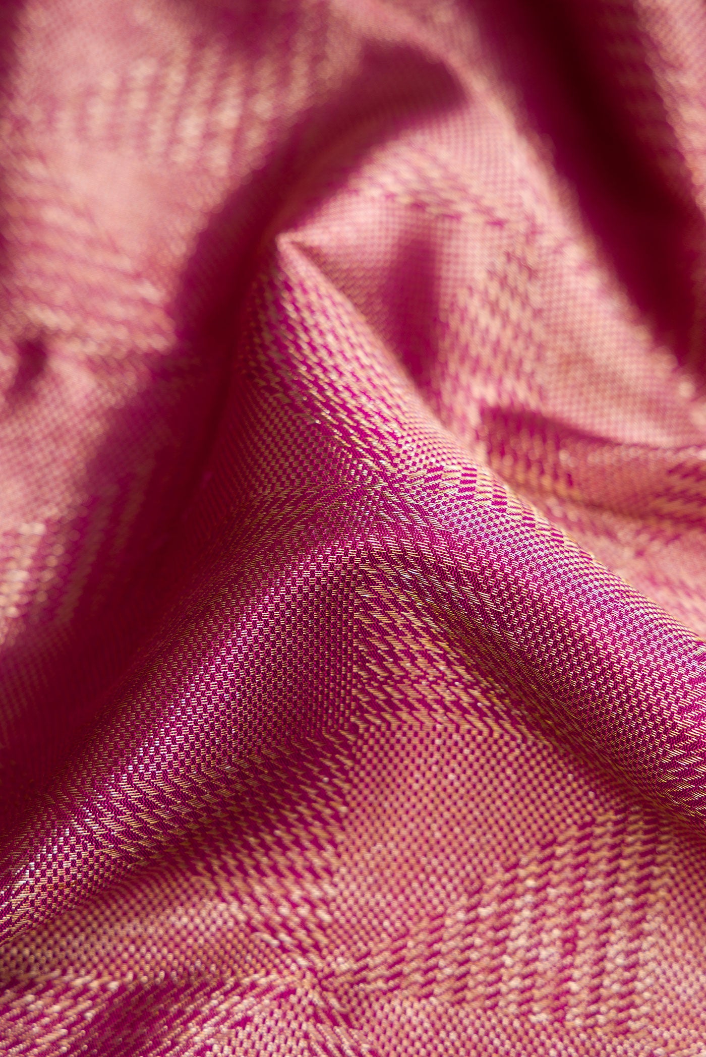 Close up of Magenta Dual Tone Kanchipuram Silk Saree with Zari Brocade on the body and Zari Border.  displaying folds