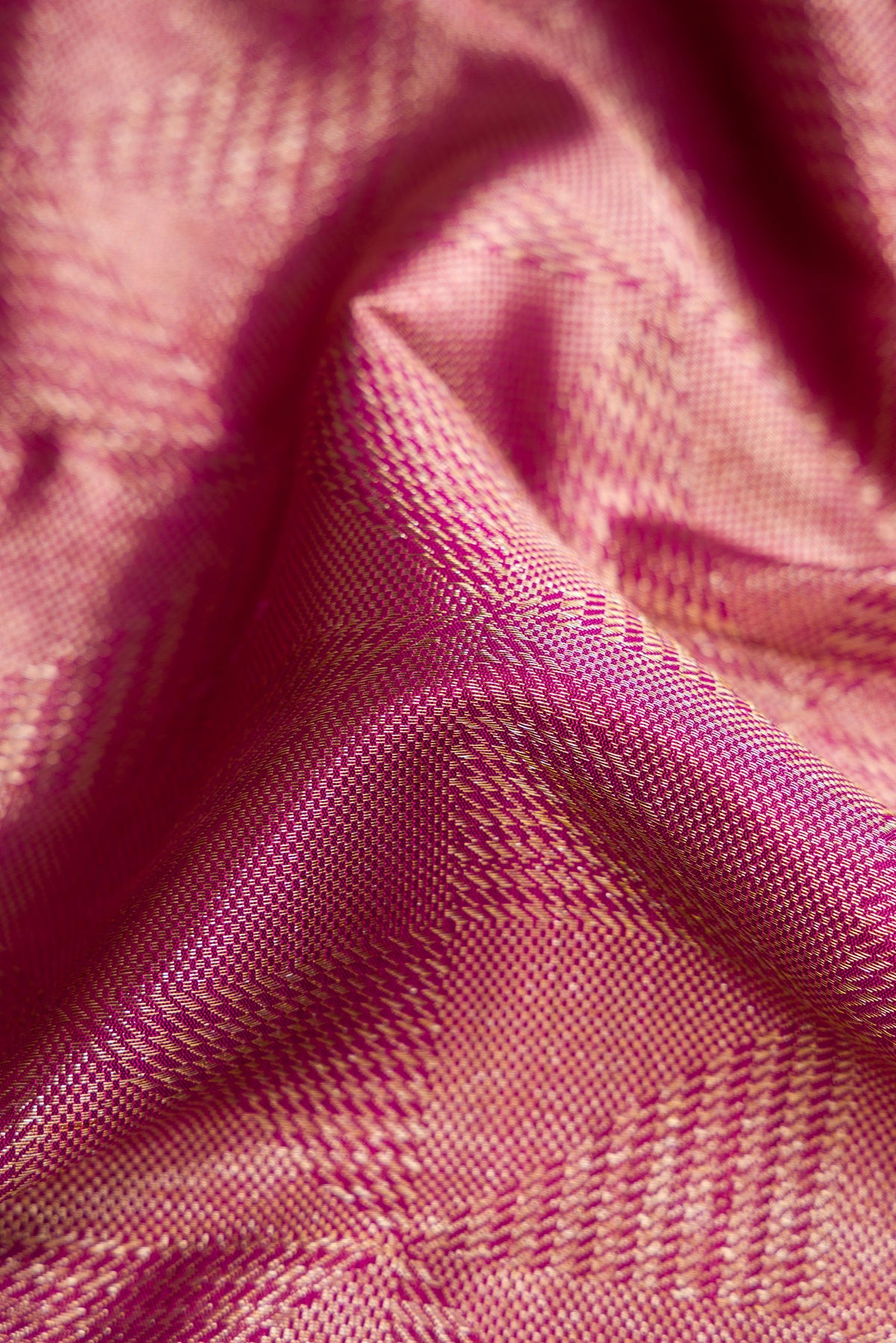 Close up of Magenta Dual Tone Kanchipuram Silk Saree with Zari Brocade on the body and Zari Border.  displaying folds