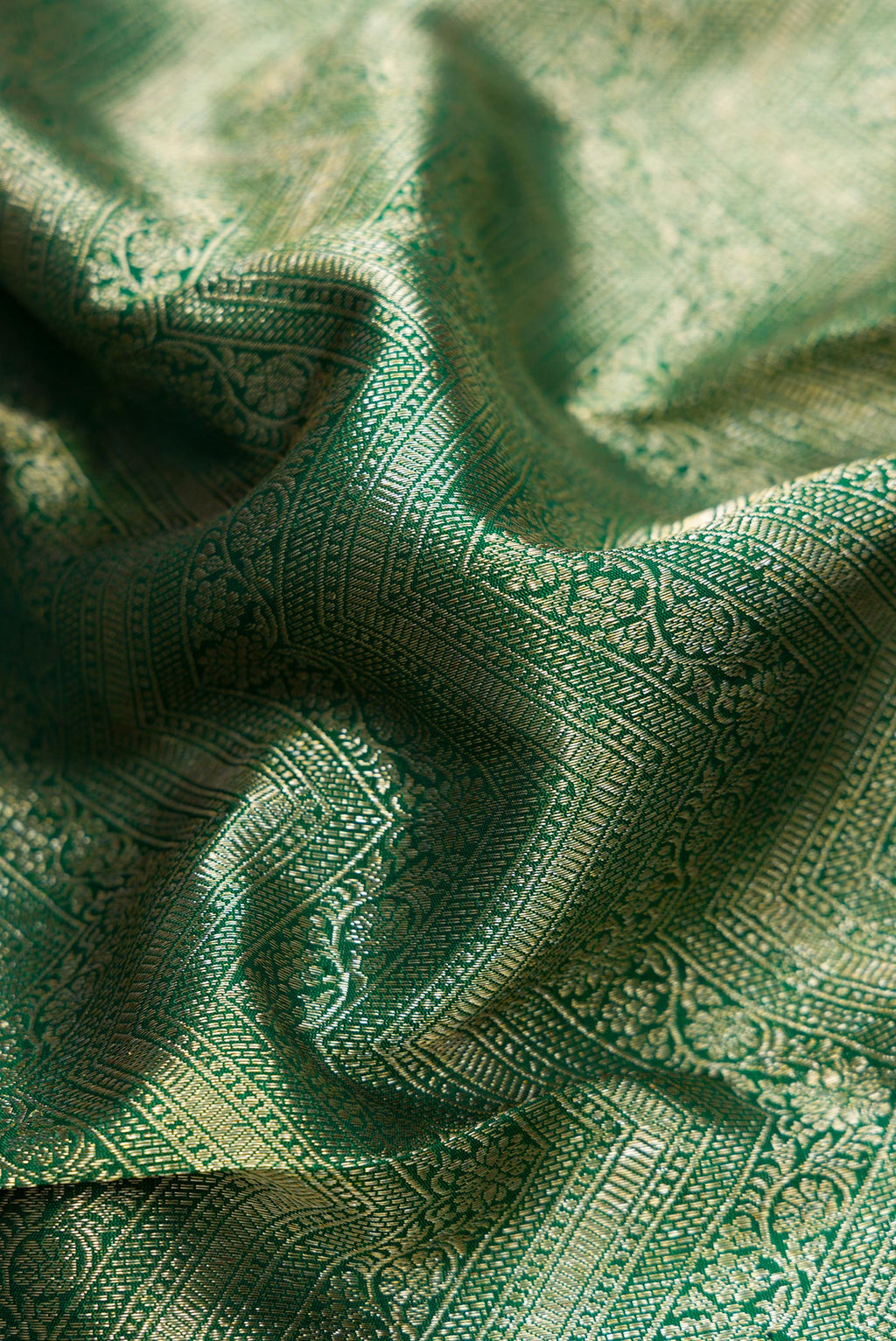 Close up of Bottle Green Dual Tone Kanchipuram Silk Saree with Zari Brocade on the body and Zari Border.  displaying folds