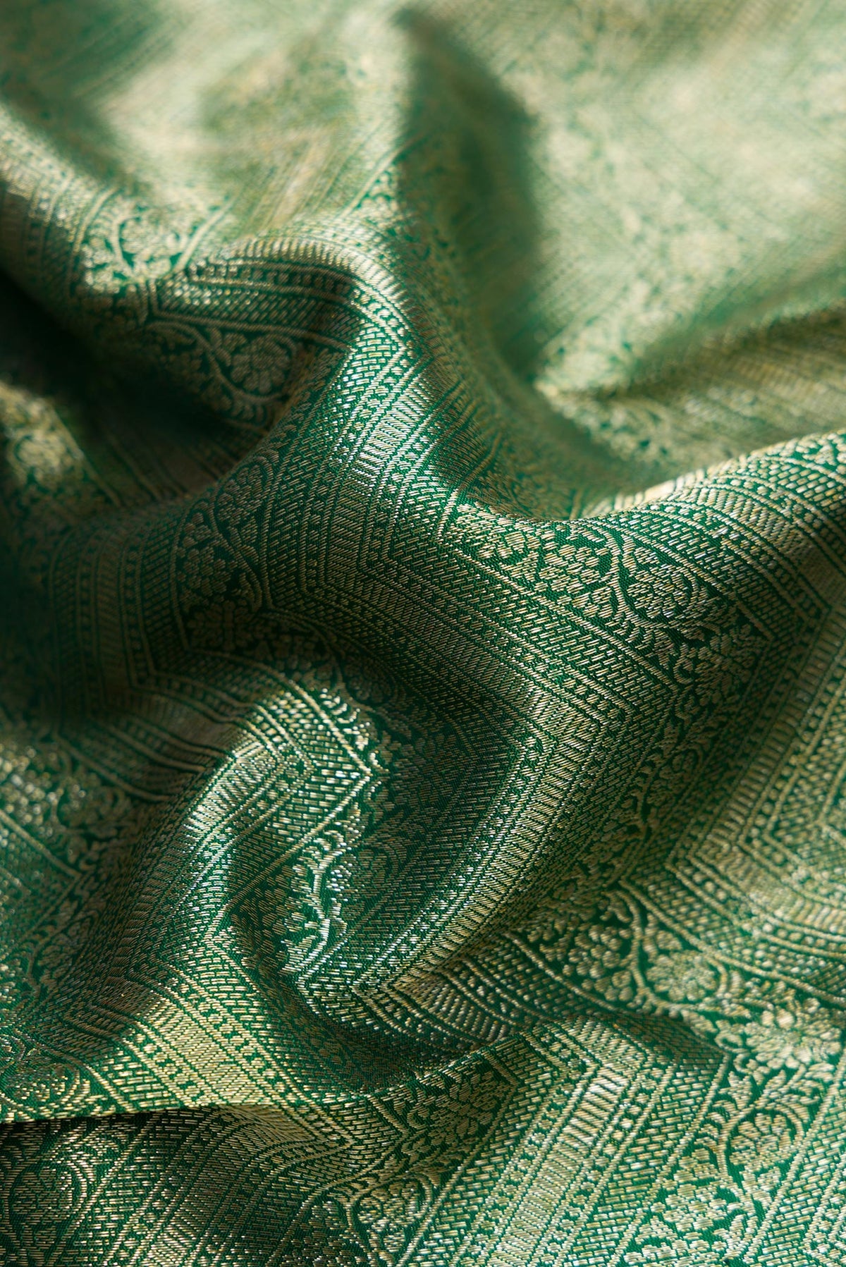 Close up of Bottle Green Dual Tone Kanchipuram Silk Saree with Zari Brocade on the body and Zari Border.  displaying folds