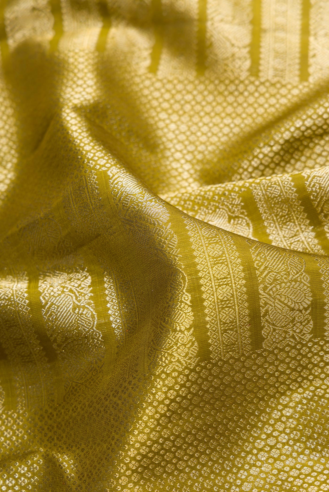 Close up of Mehandi Green Dual Tone Kanchipuram Silk Saree with Zari Brocade on the body and Zari Border.  displaying folds