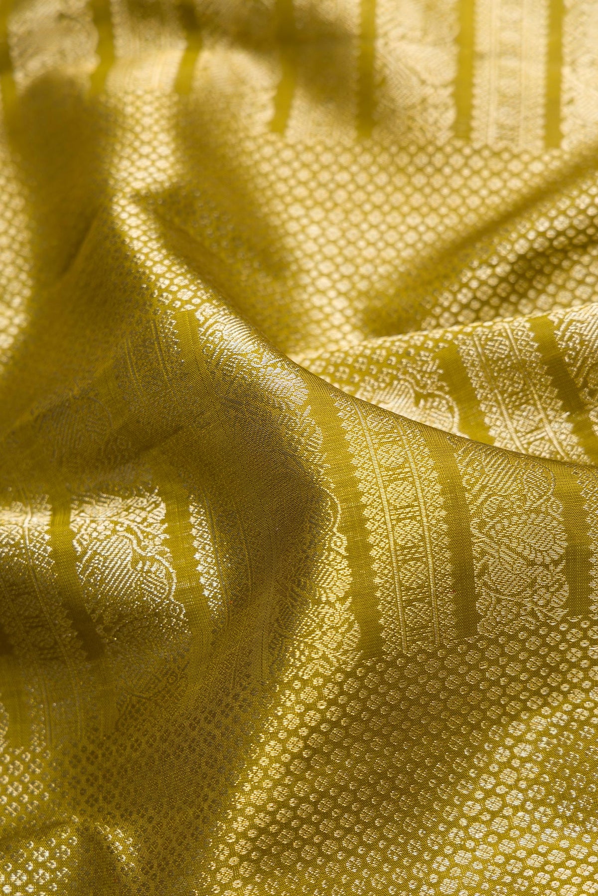 Close up of Mehandi Green Dual Tone Kanchipuram Silk Saree with Zari Brocade on the body and Zari Border.  displaying folds