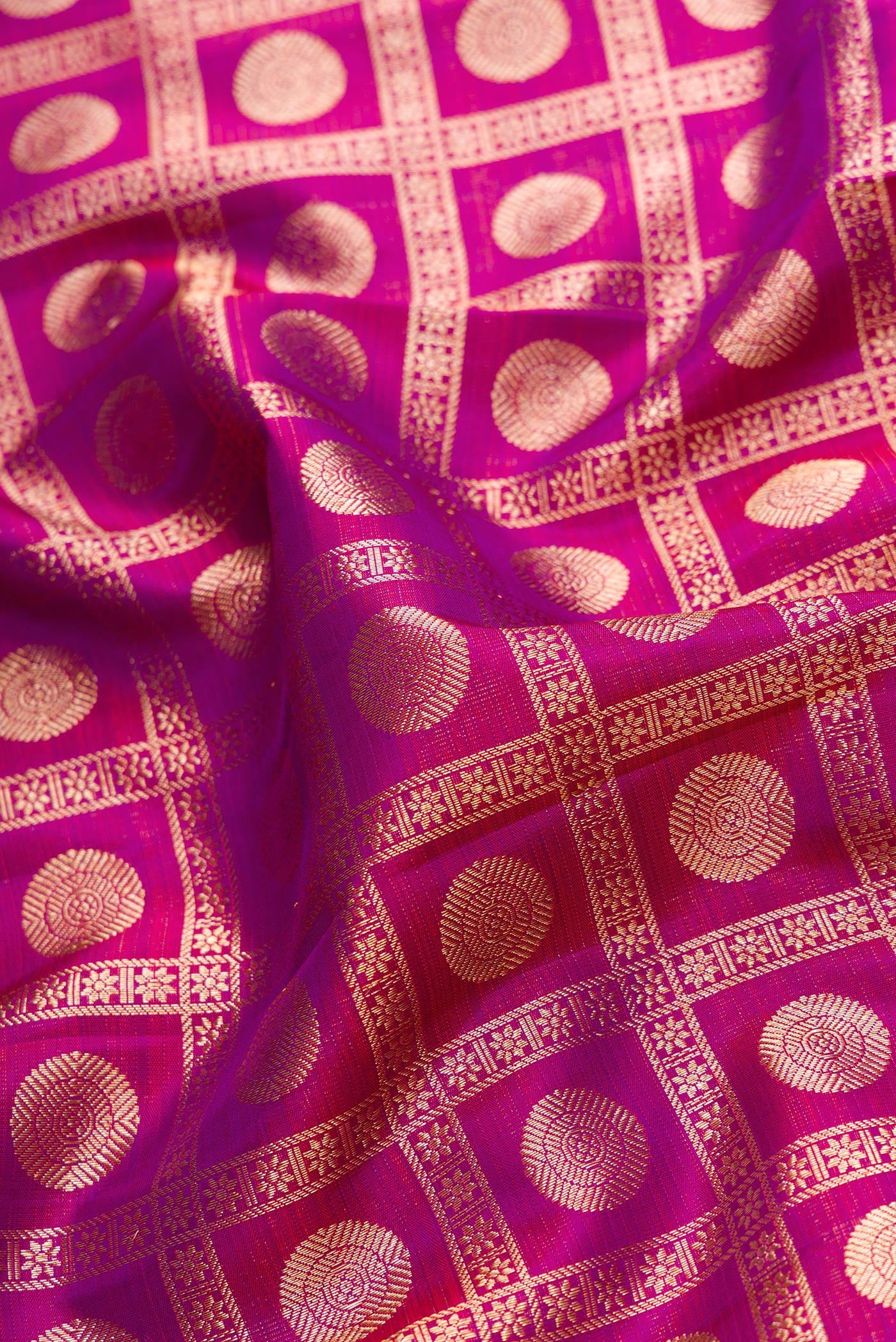 Close up of Magenta Dual Tone Kanchipuram Silk Saree with Zari Brocade on the body and Zari Border.  displaying folds