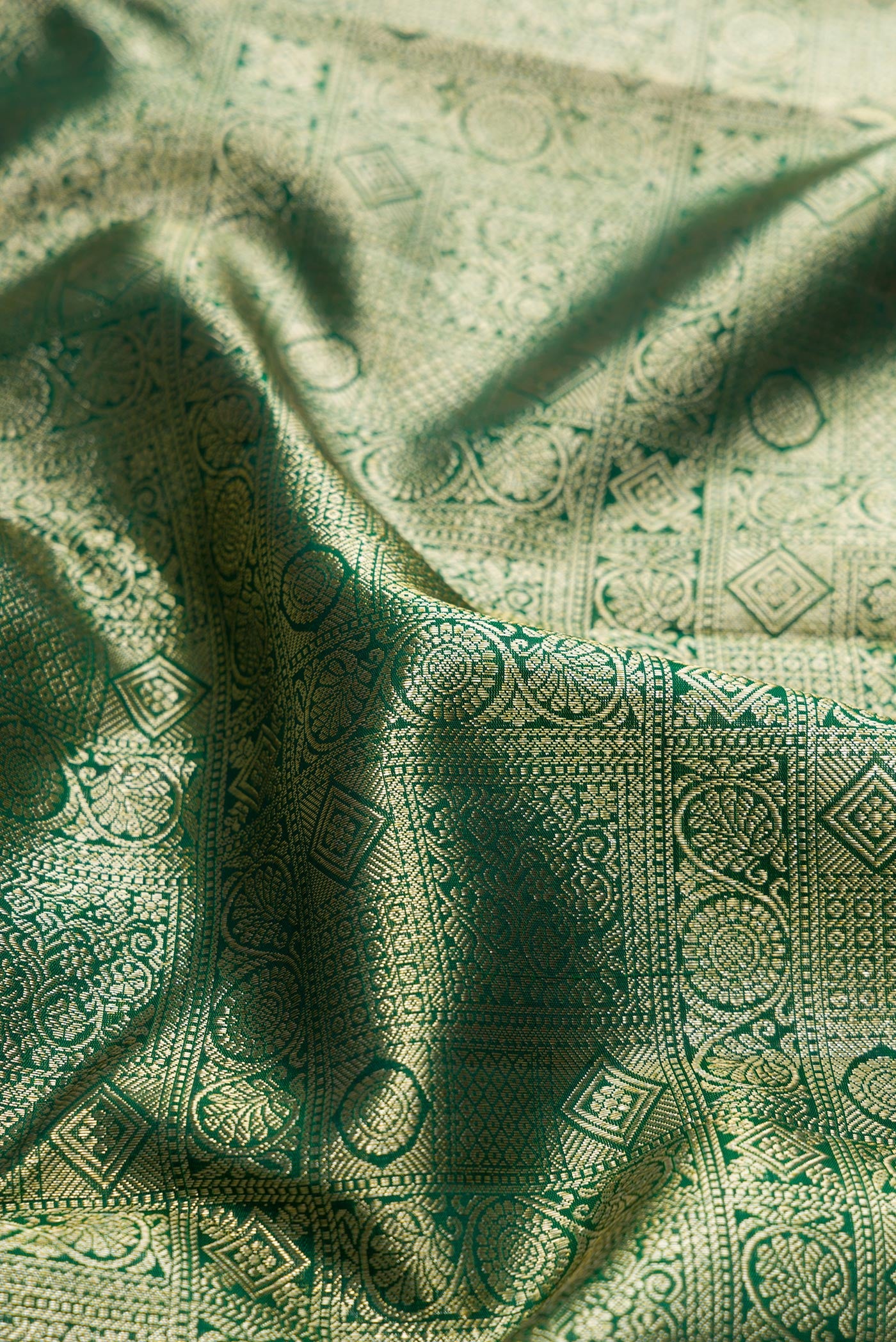 Close up of Bottle Green Dual Tone Kanchipuram Silk Saree with Zari Brocade on the body and Zari Border.  displaying folds