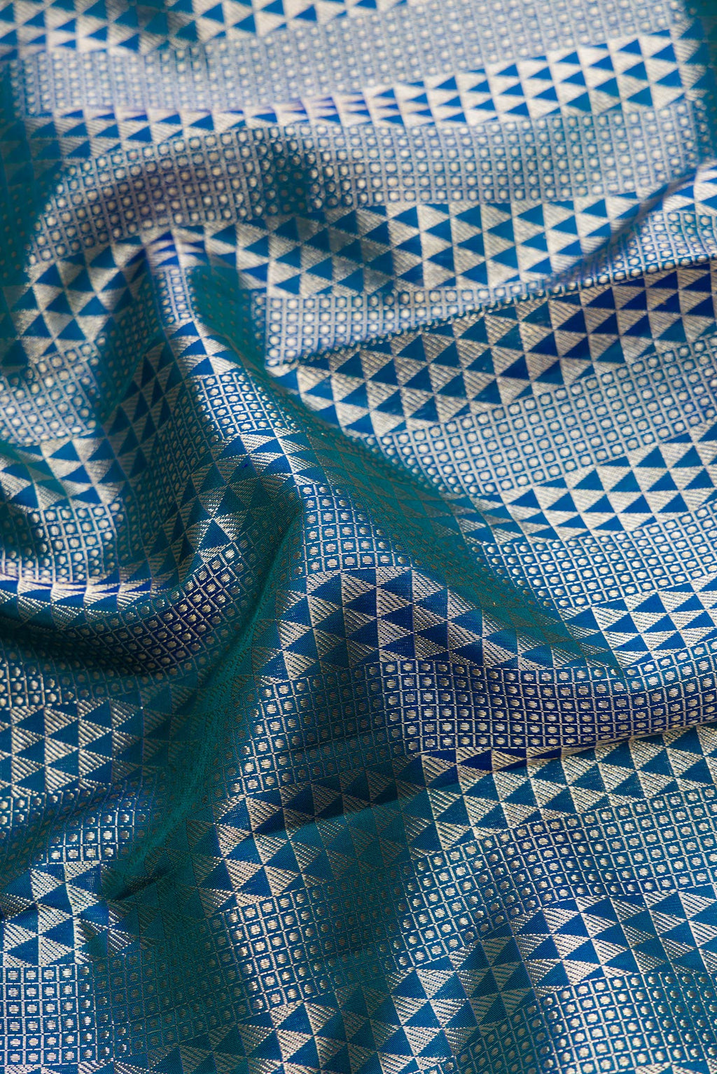 Close up of Peacock Blue Dual Tone Kanchipuram Silk Saree with Zari Brocade on the body and Zari Border.  displaying folds